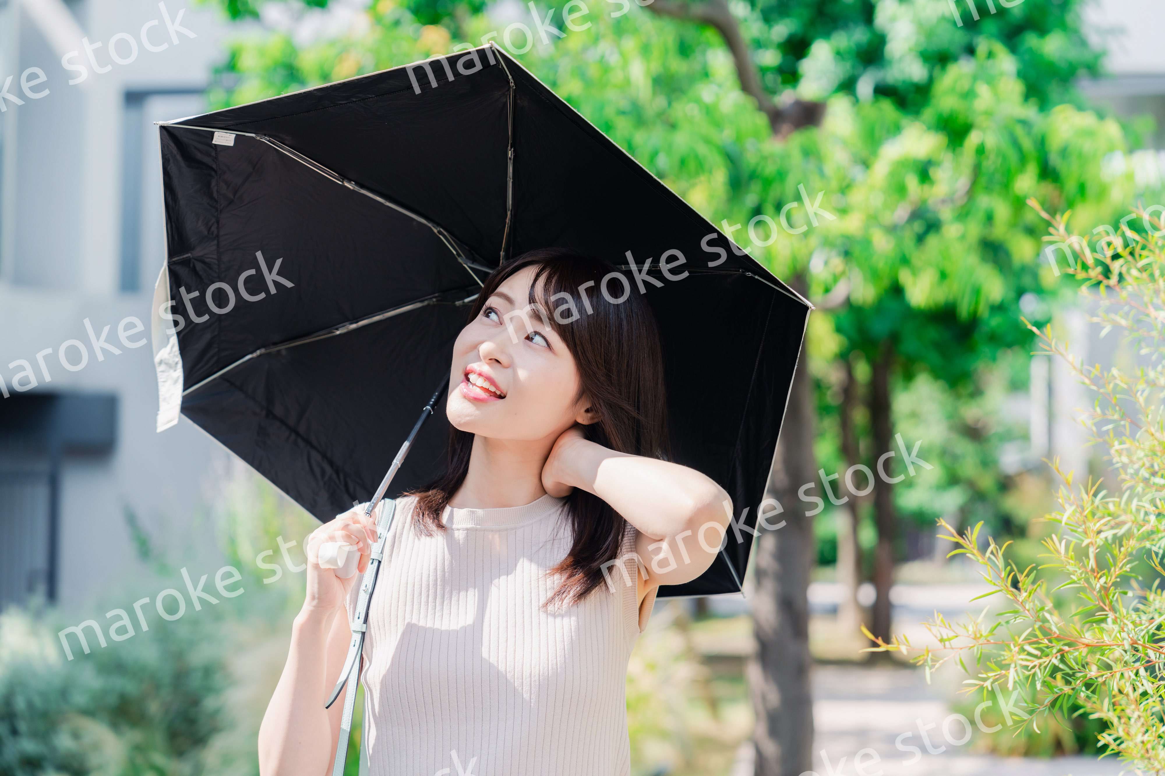 日傘を差して外を歩く若い女性