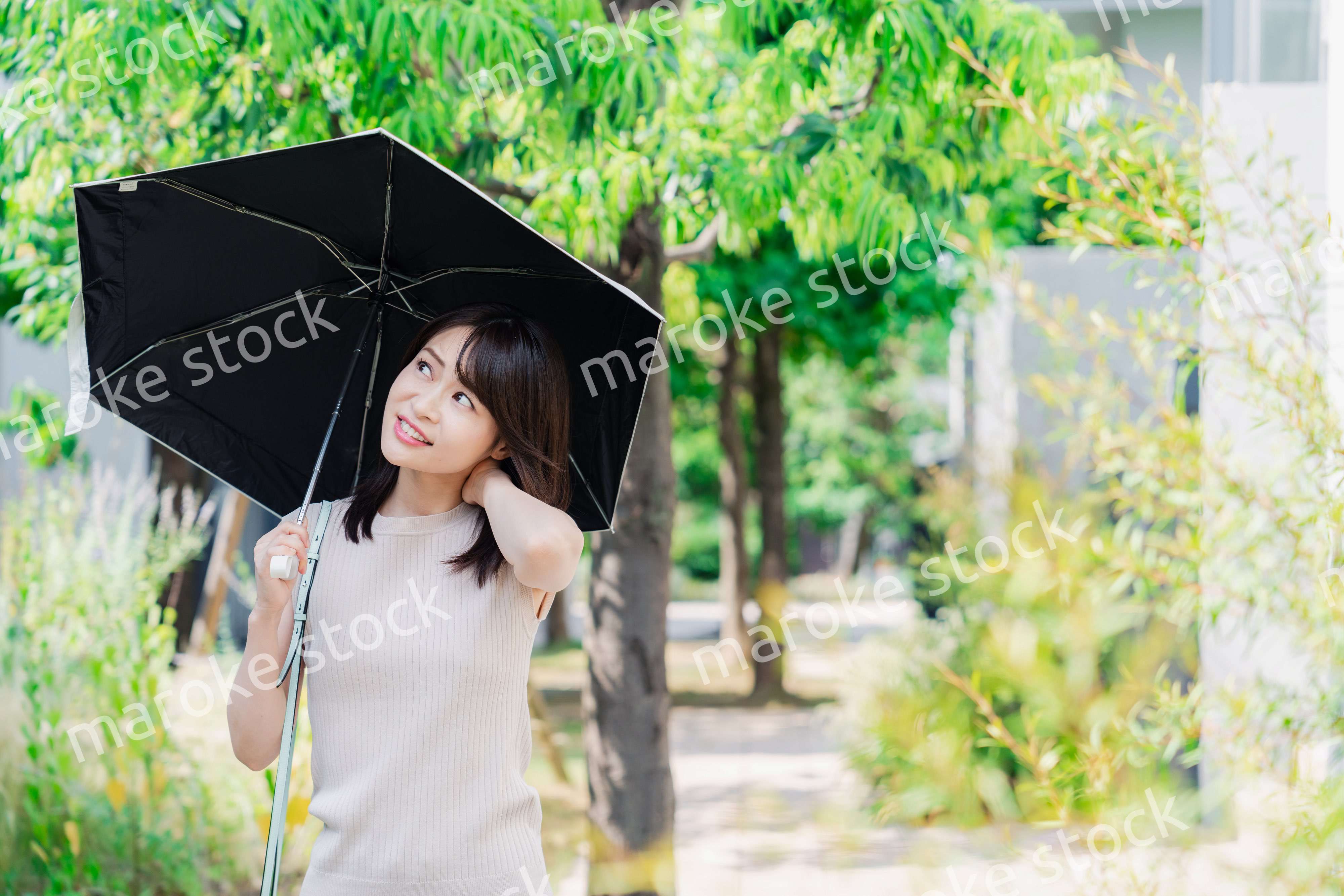 日傘を差して外を歩く若い女性