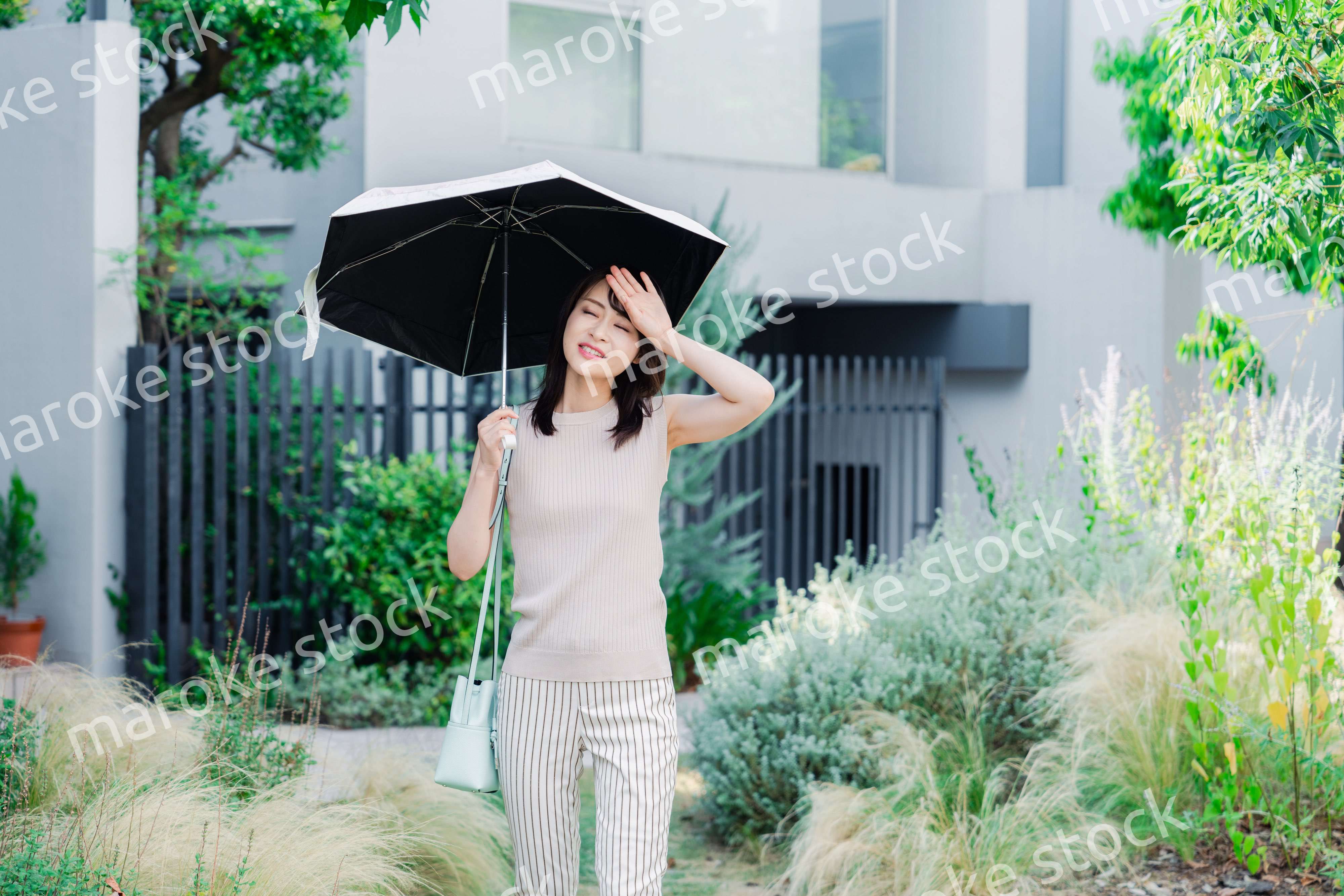 日傘を差して外を歩く若い女性