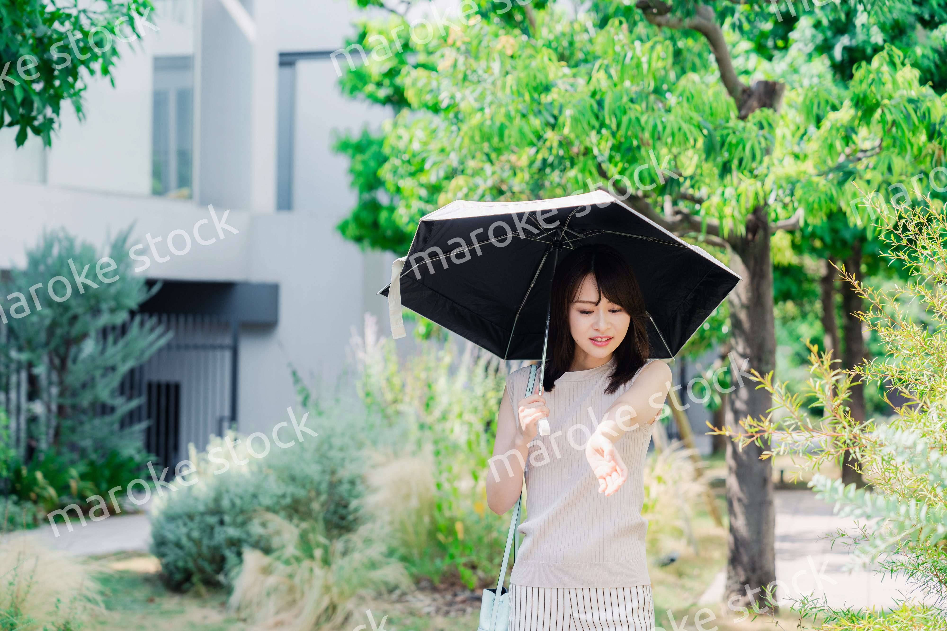 日傘を差して外を歩く若い女性