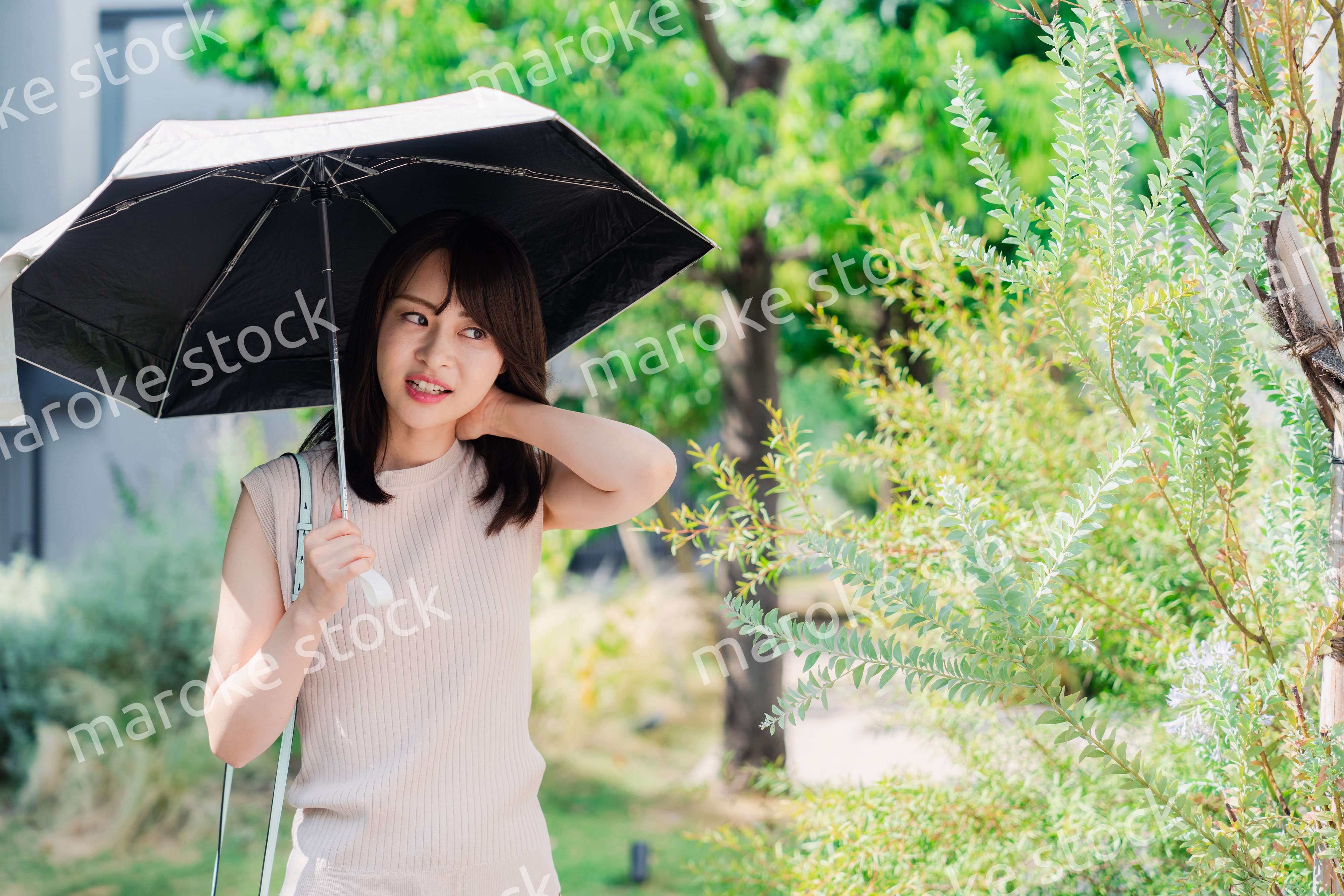 日傘を差して外を歩く若い女性