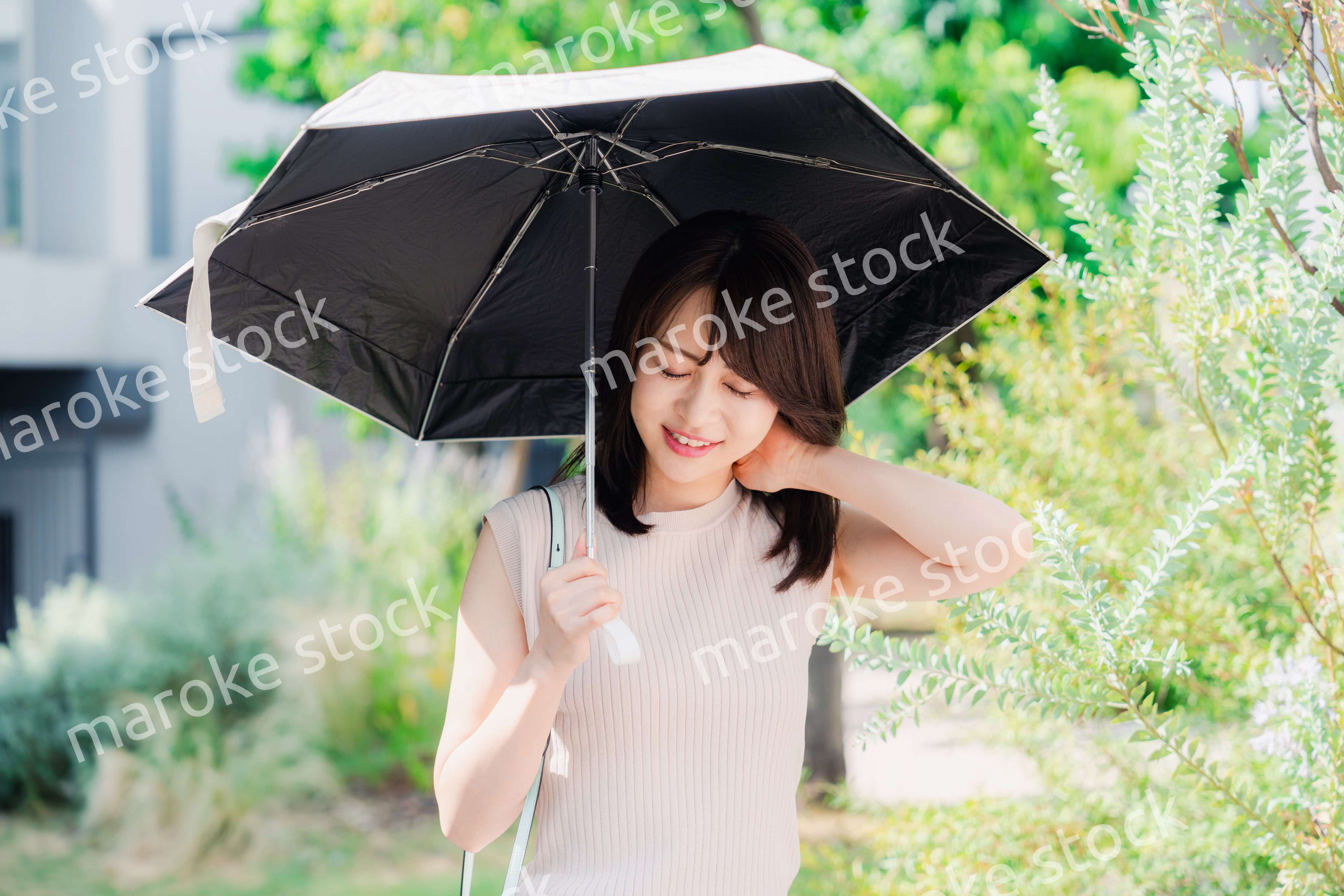 日傘を差して外を歩く若い女性