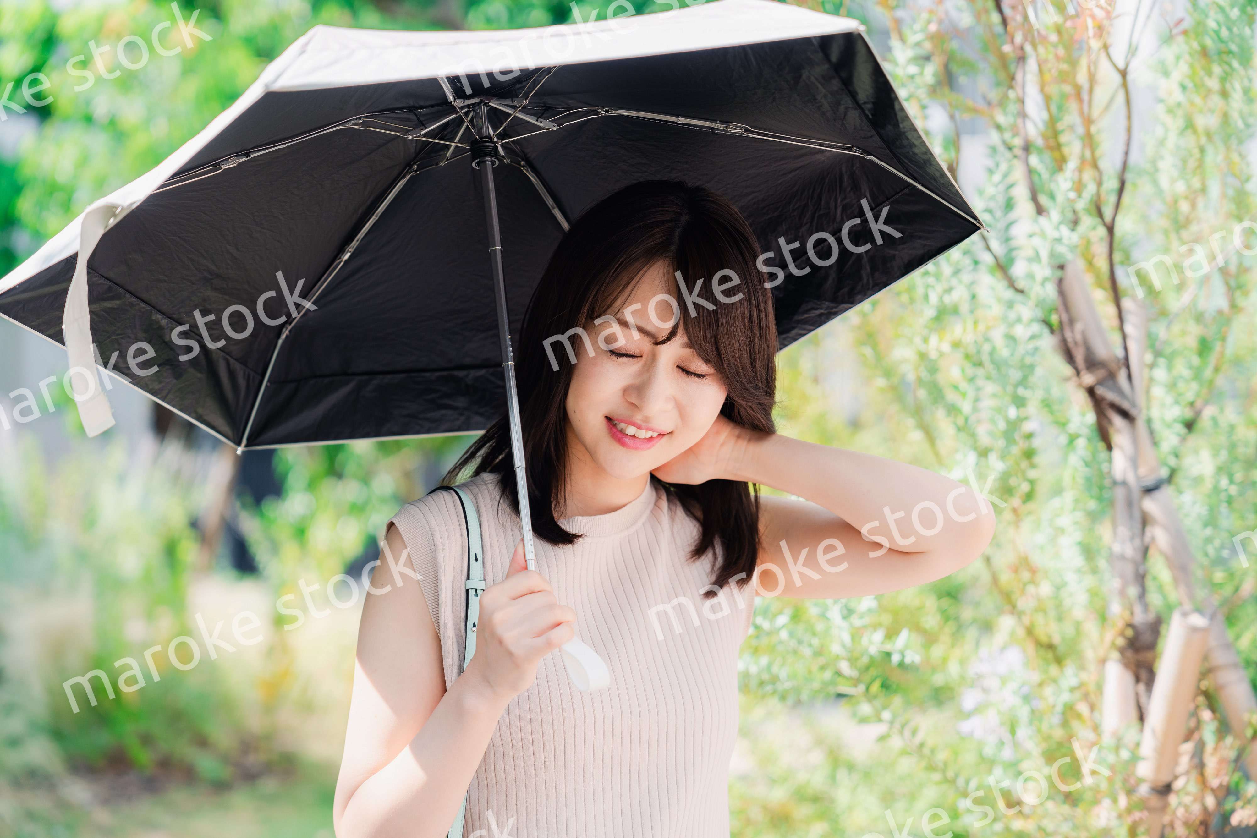 日傘を差して外を歩く若い女性