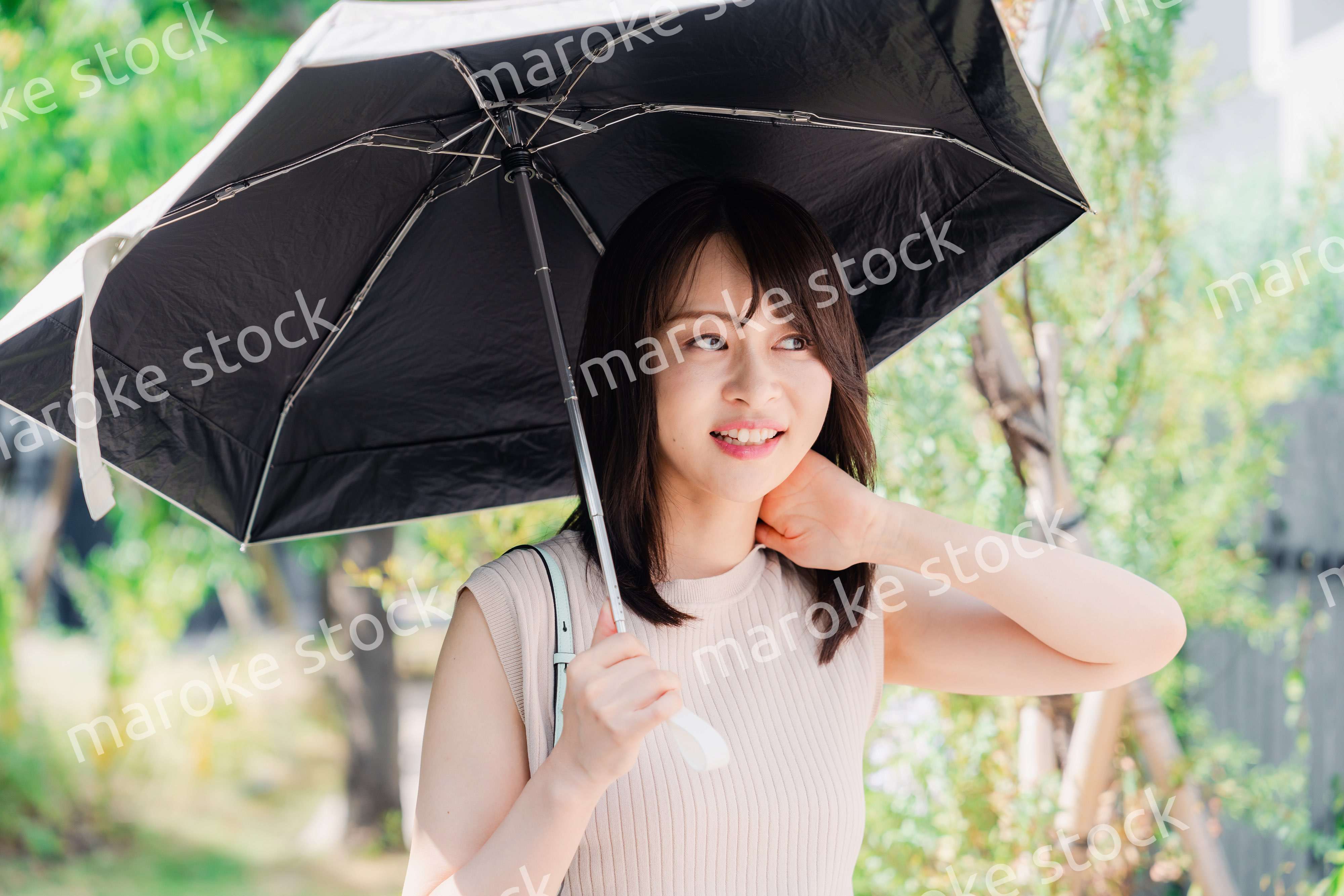 日傘を差して外を歩く若い女性