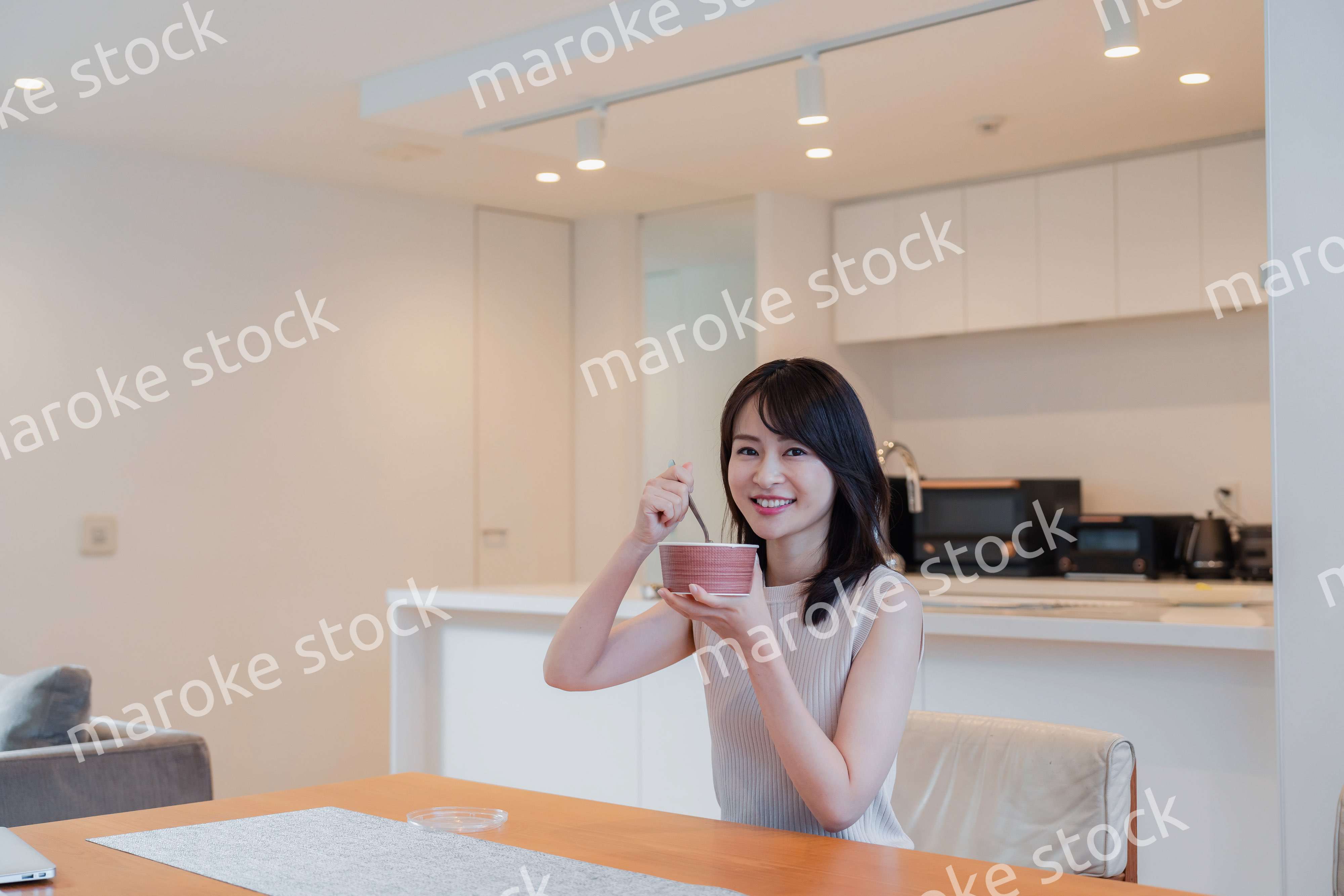 家でコンビニ弁当を食べる若い女性