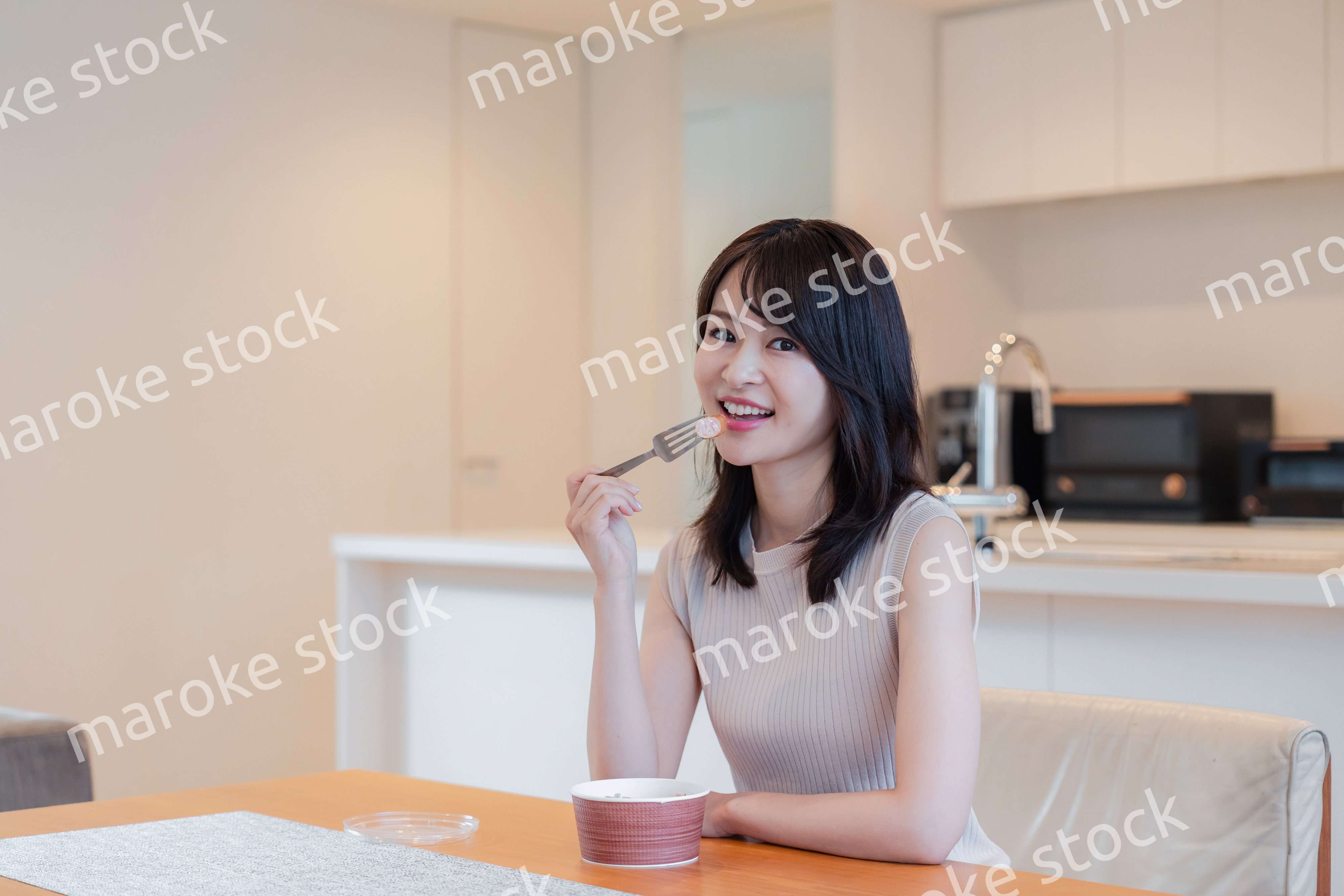 家でコンビニ弁当を食べる若い女性