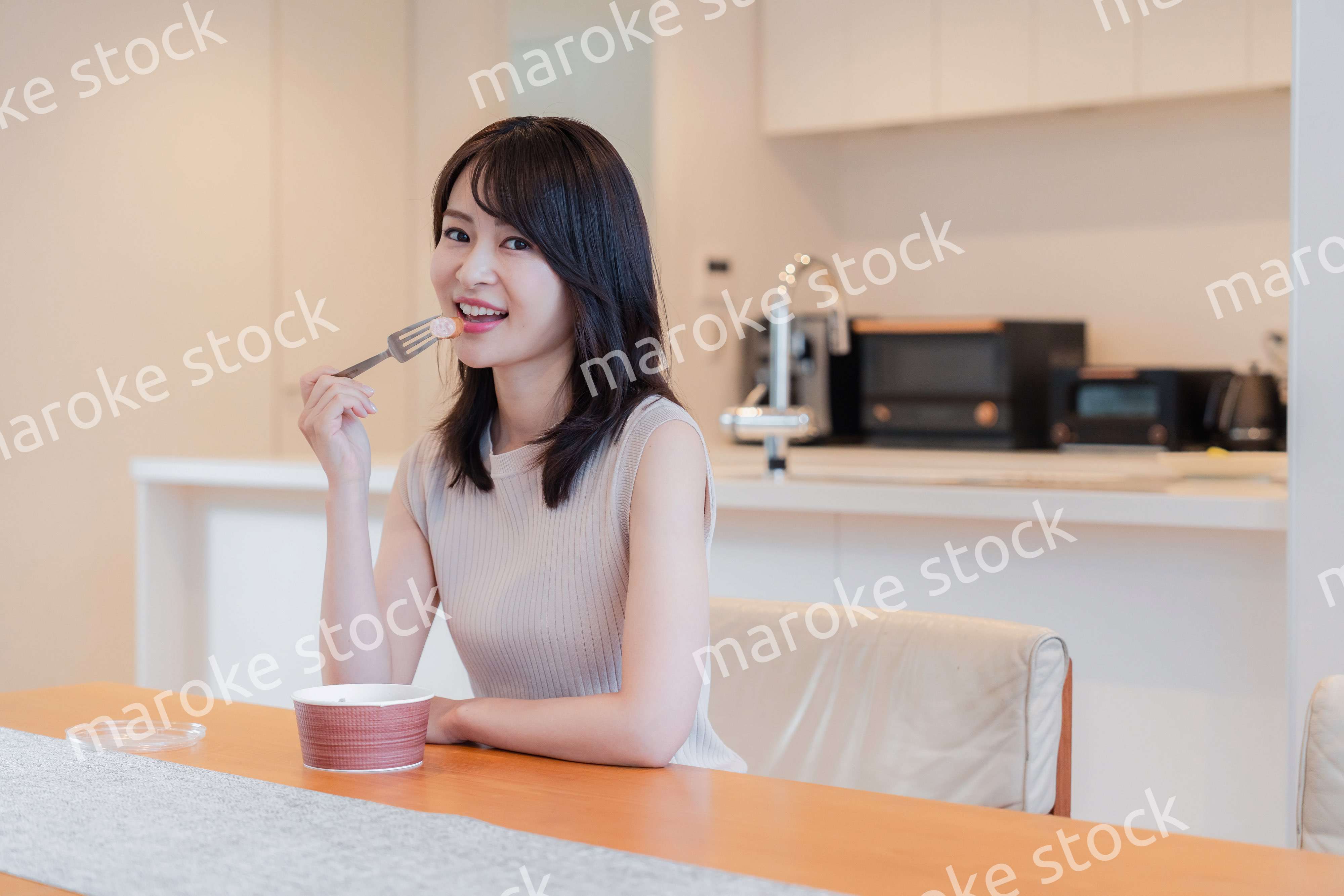 家でコンビニ弁当を食べる若い女性