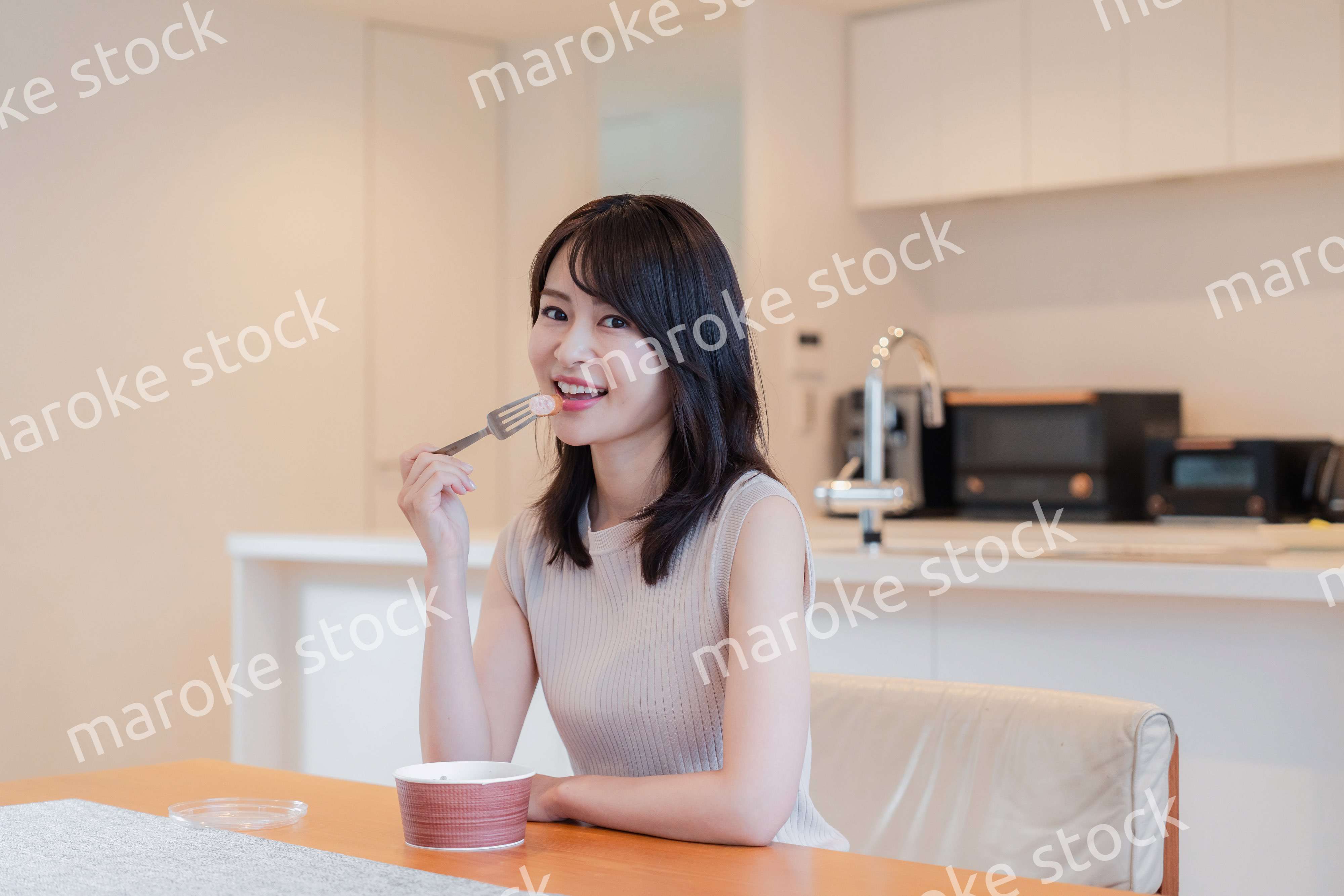 家でコンビニ弁当を食べる若い女性