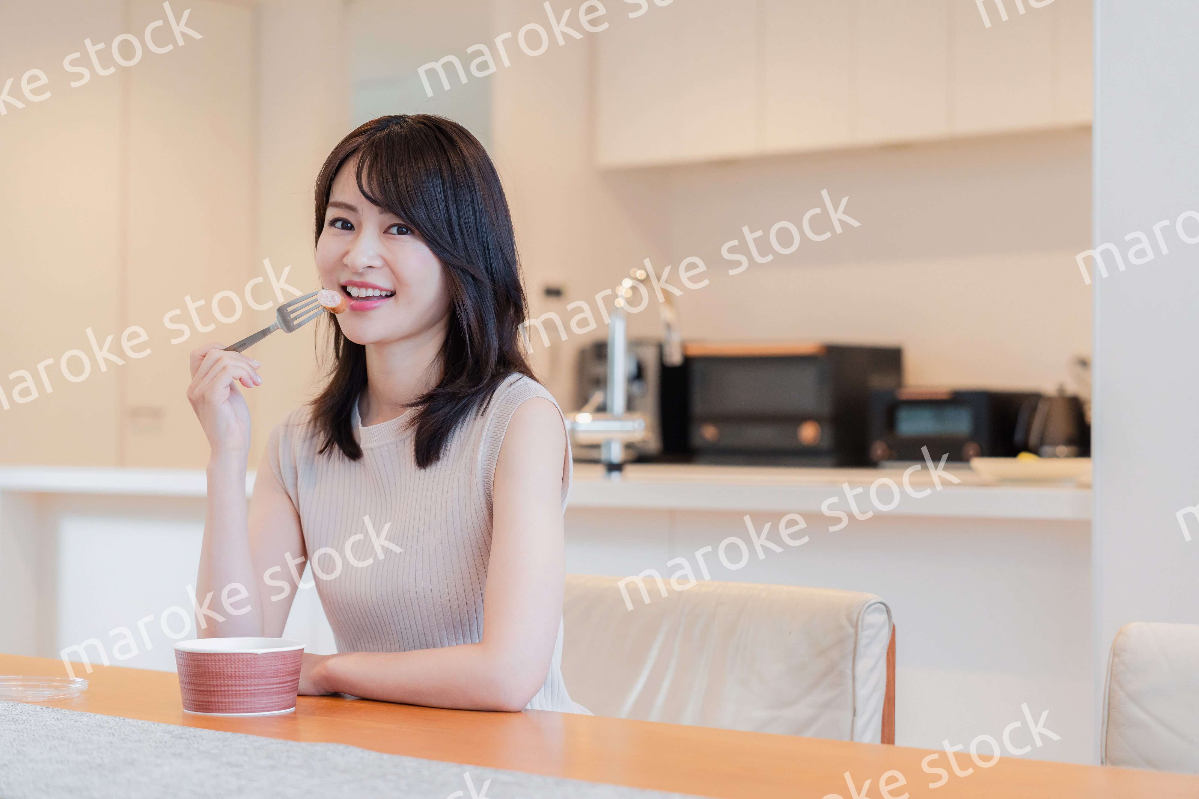 家でコンビニ弁当を食べる若い女性