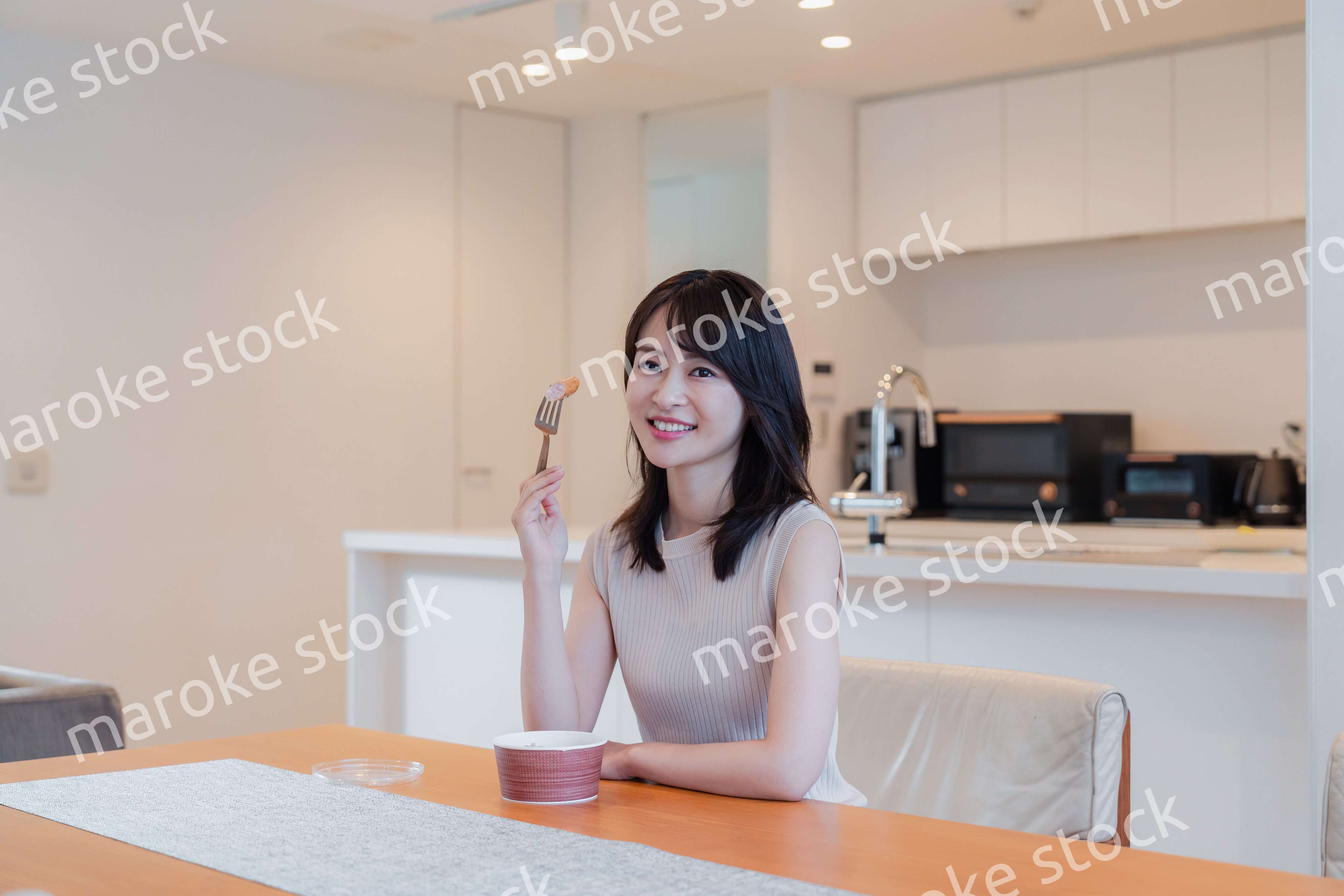 家でコンビニ弁当を食べる若い女性