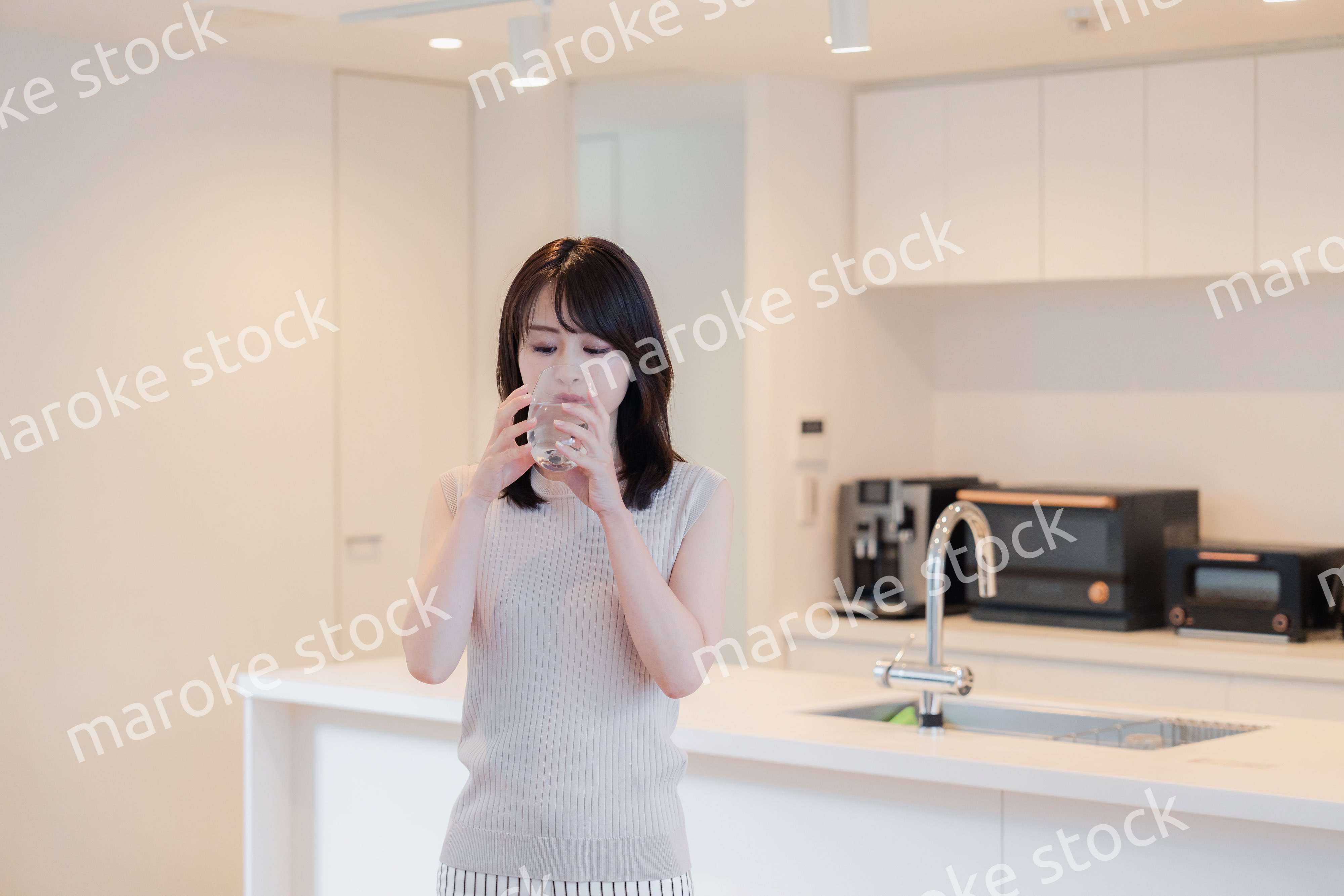 家で水を飲む若い女性