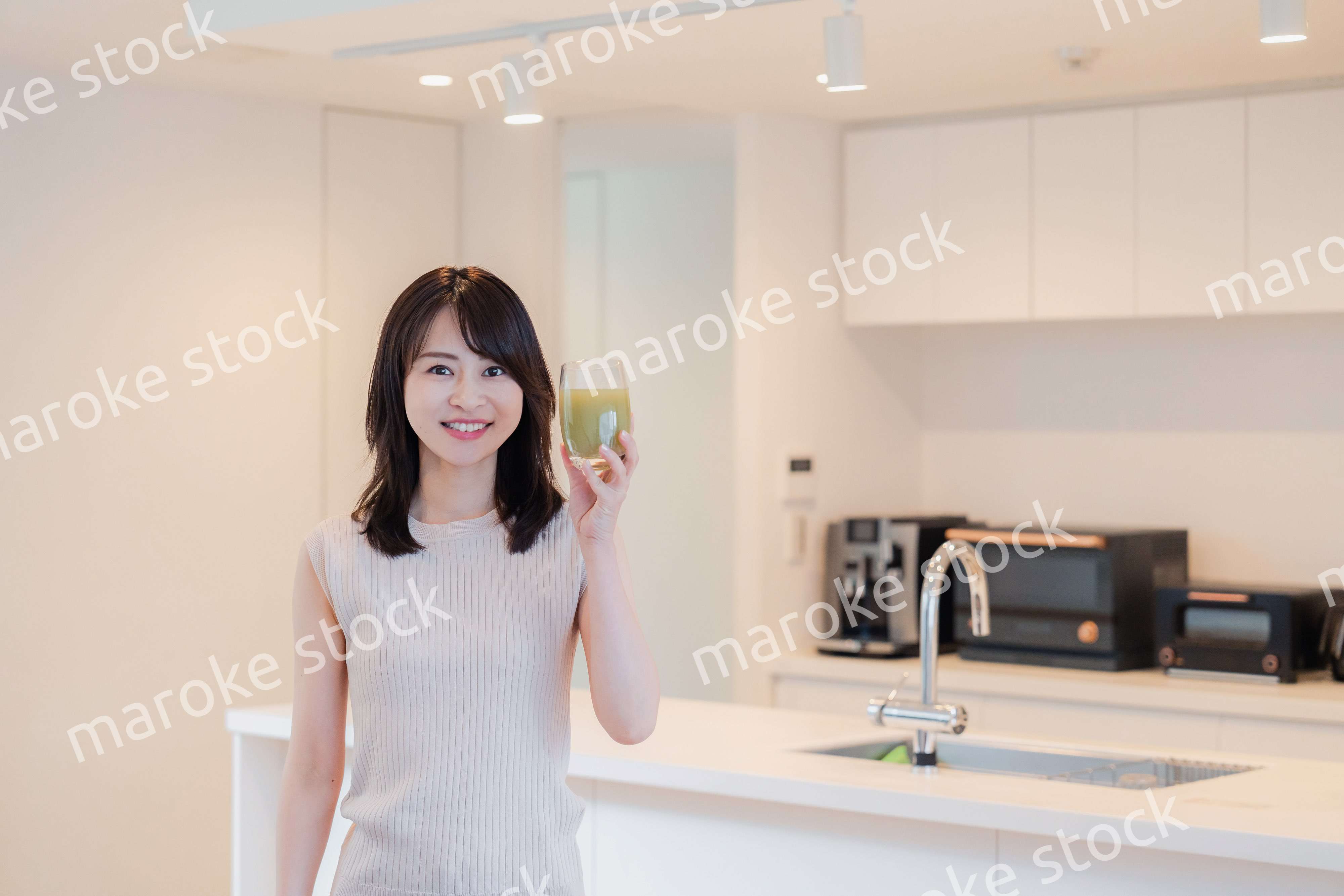 家でスムージーを飲む若い女性