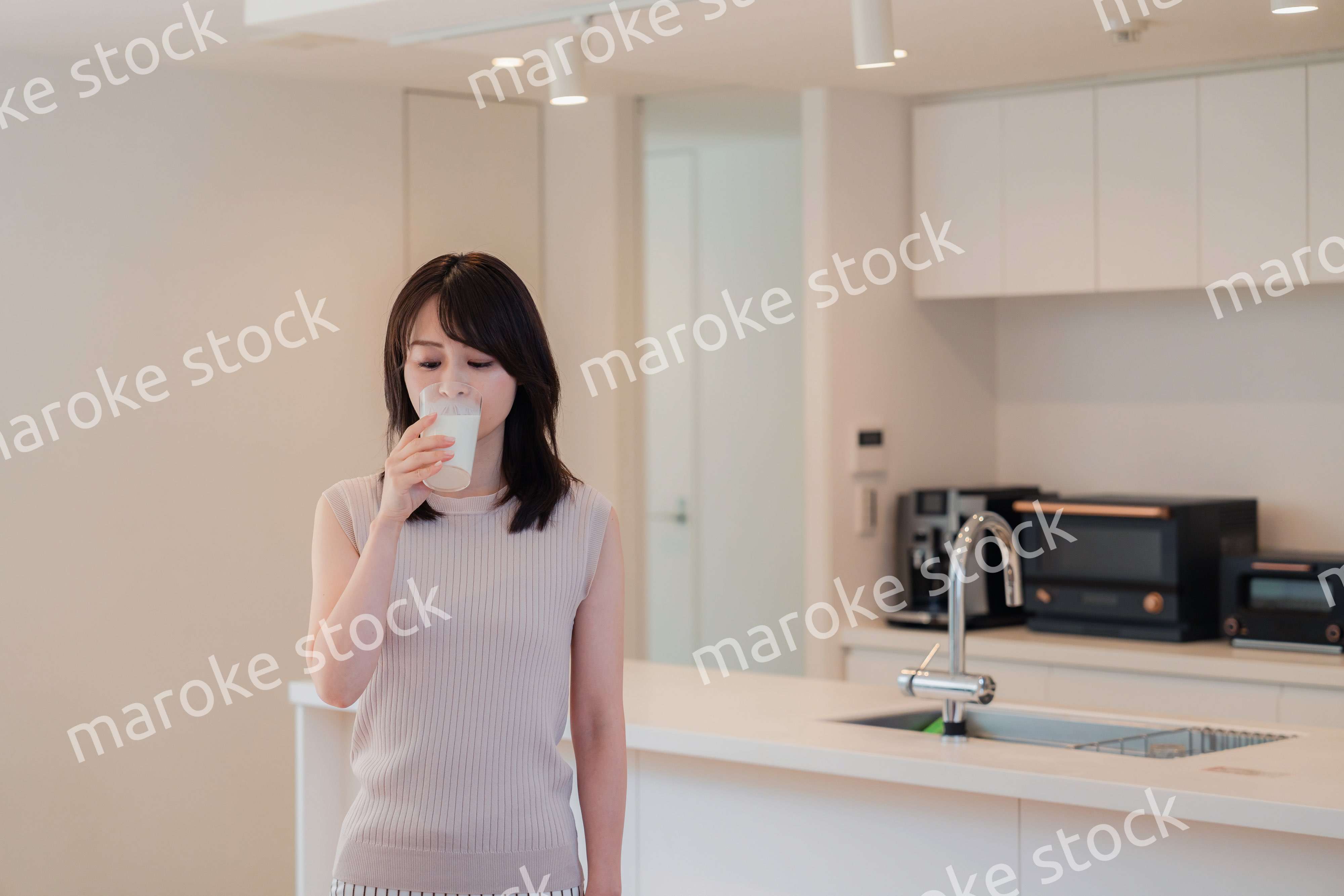 家でミルクを飲む若い女性