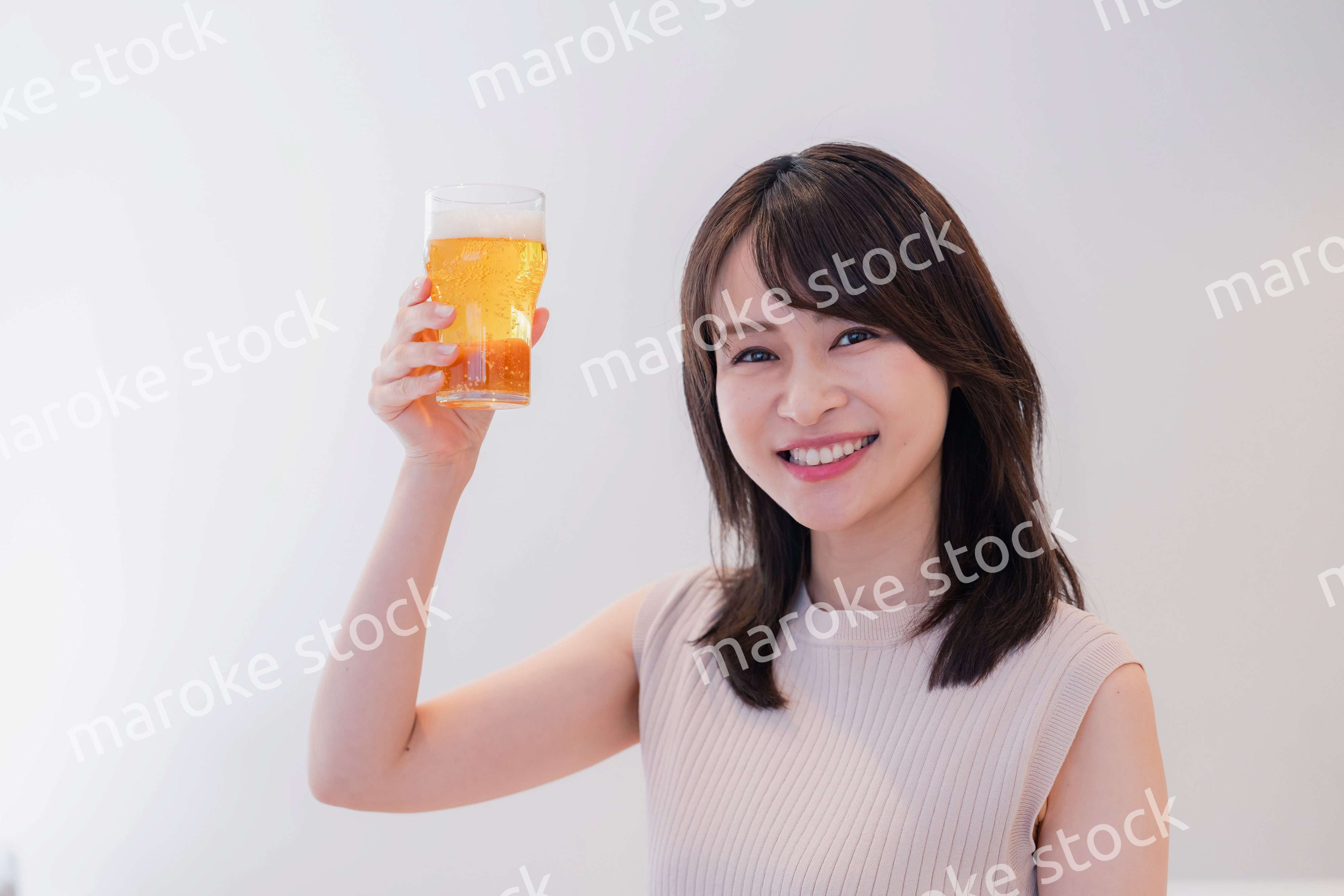 笑顔でビールを飲む若い女性