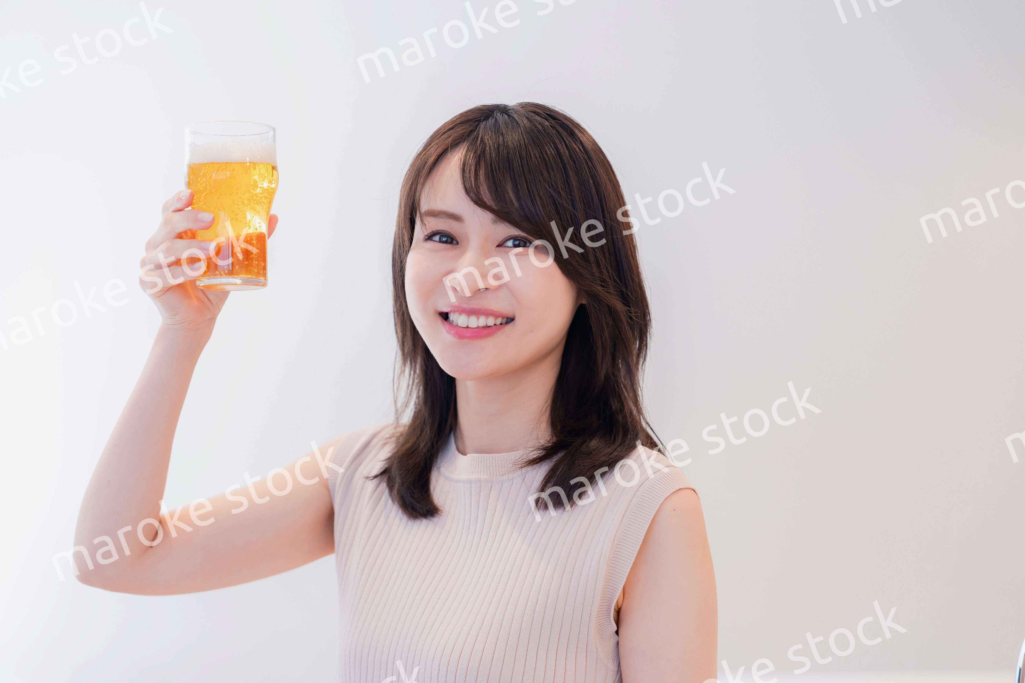 笑顔でビールを飲む若い女性