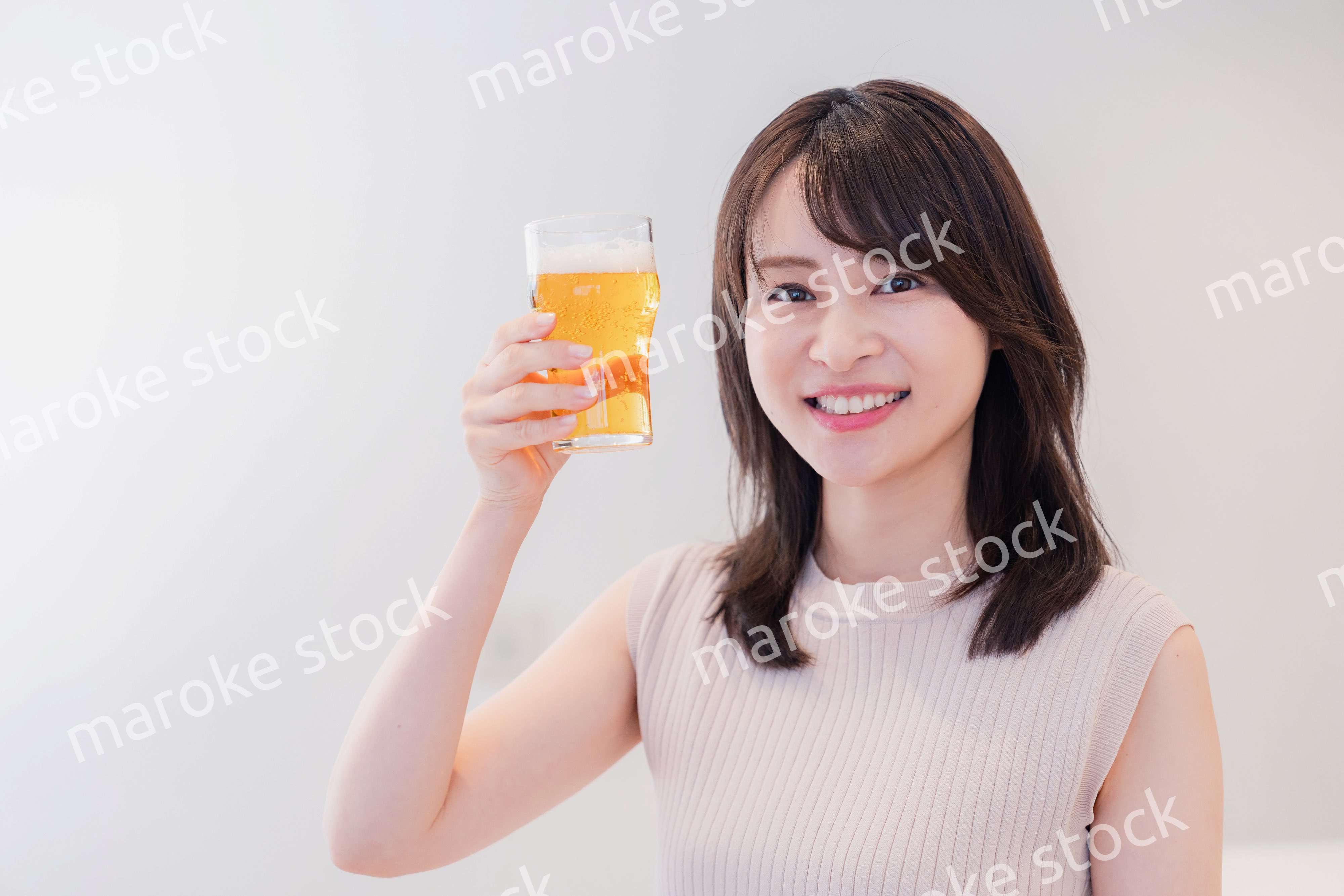 笑顔でビールを飲む若い女性