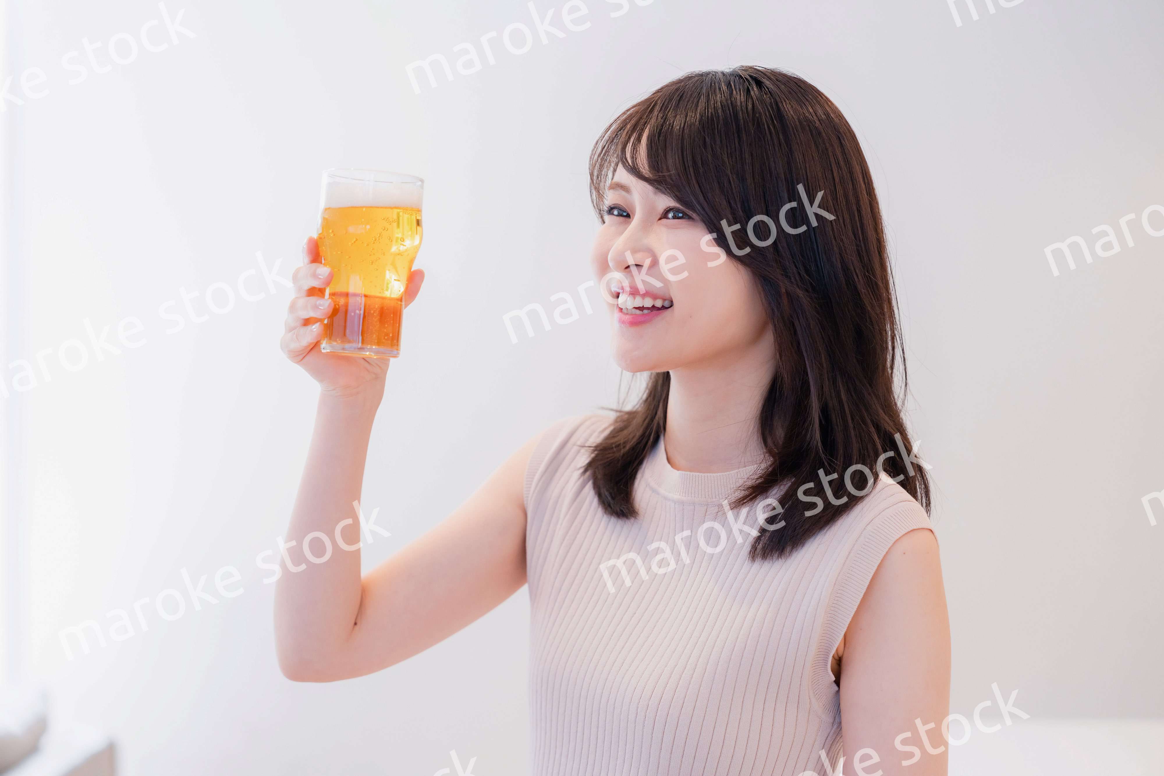 笑顔でビールを飲む若い女性