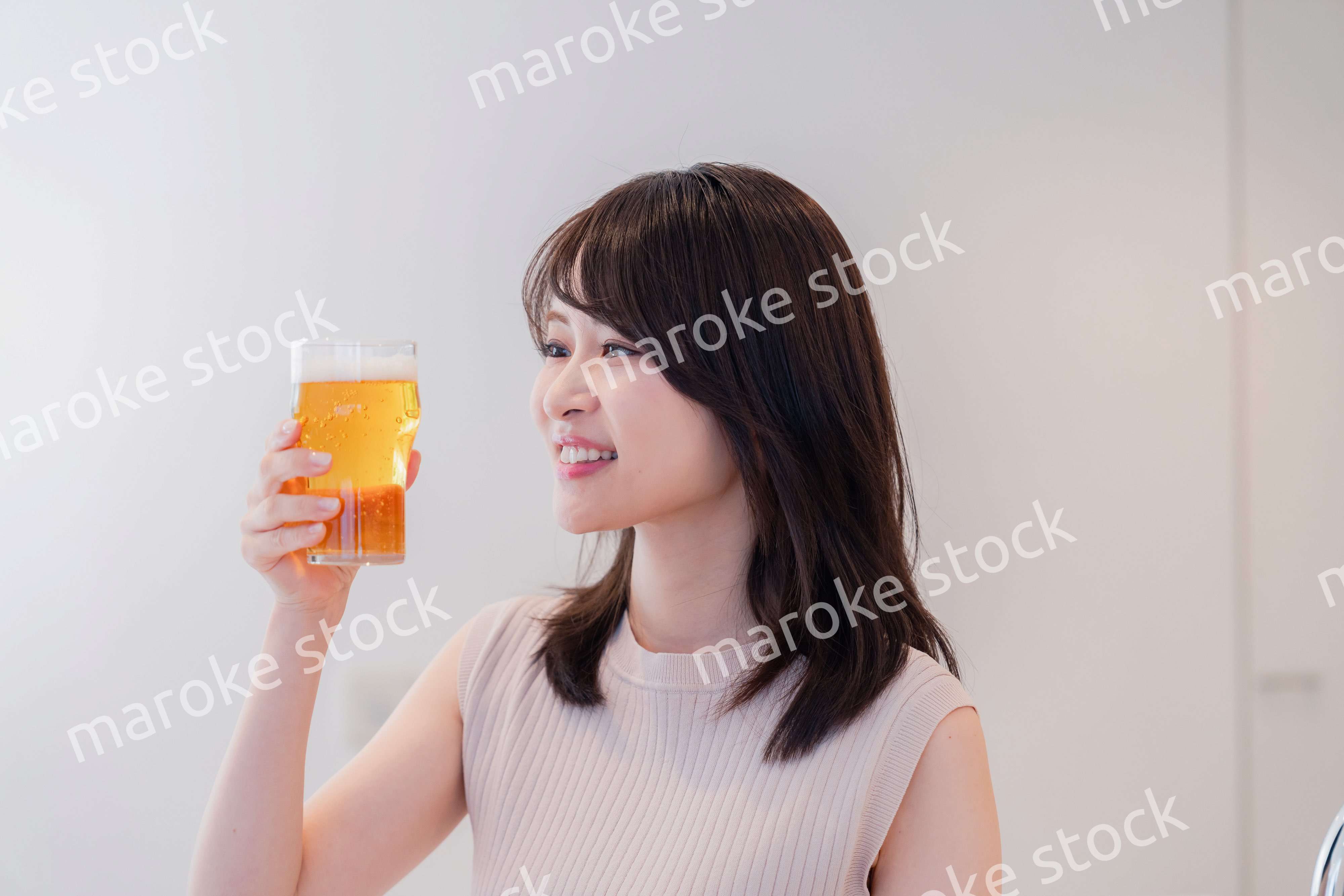 笑顔でビールを飲む若い女性