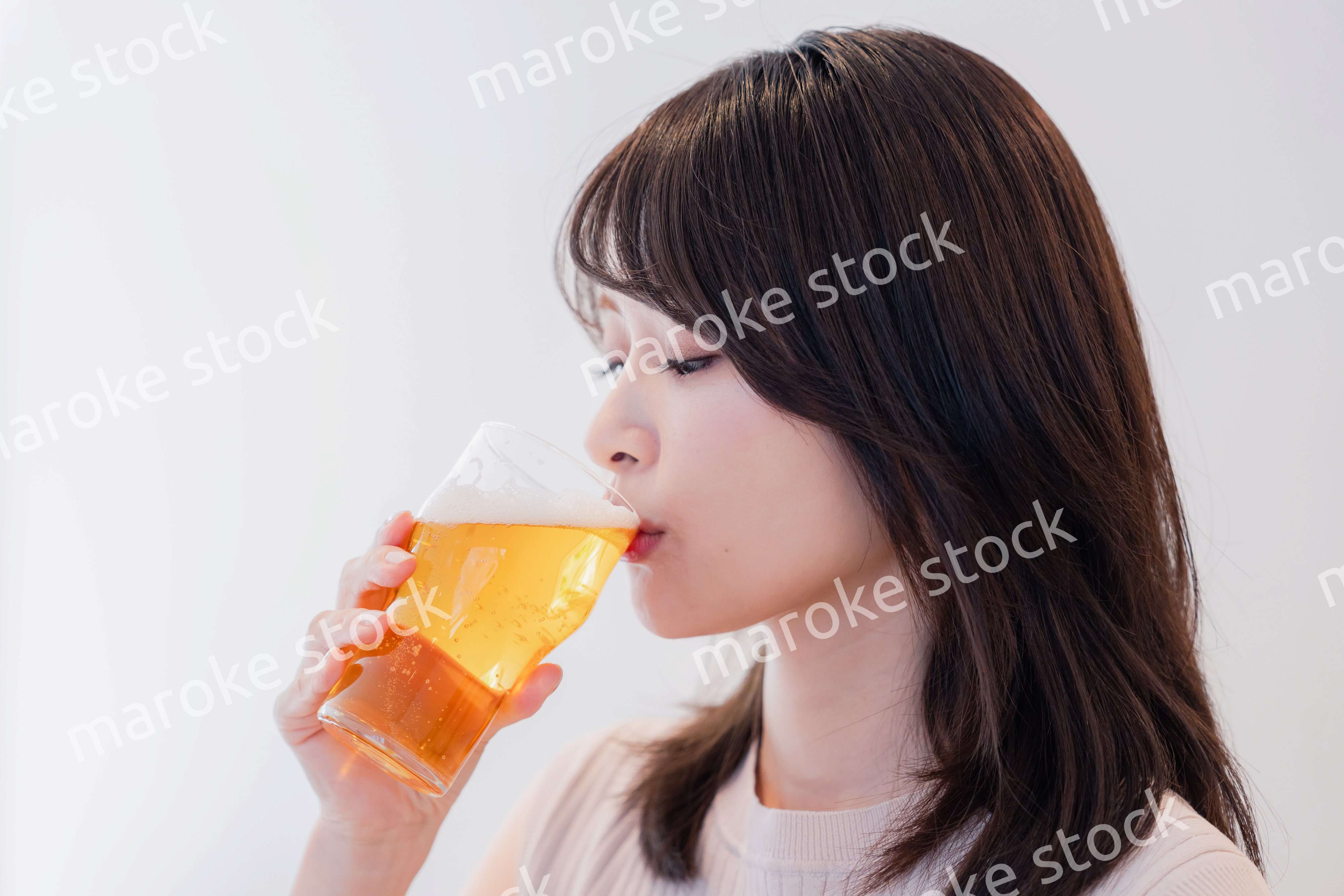 笑顔でビールを飲む若い女性