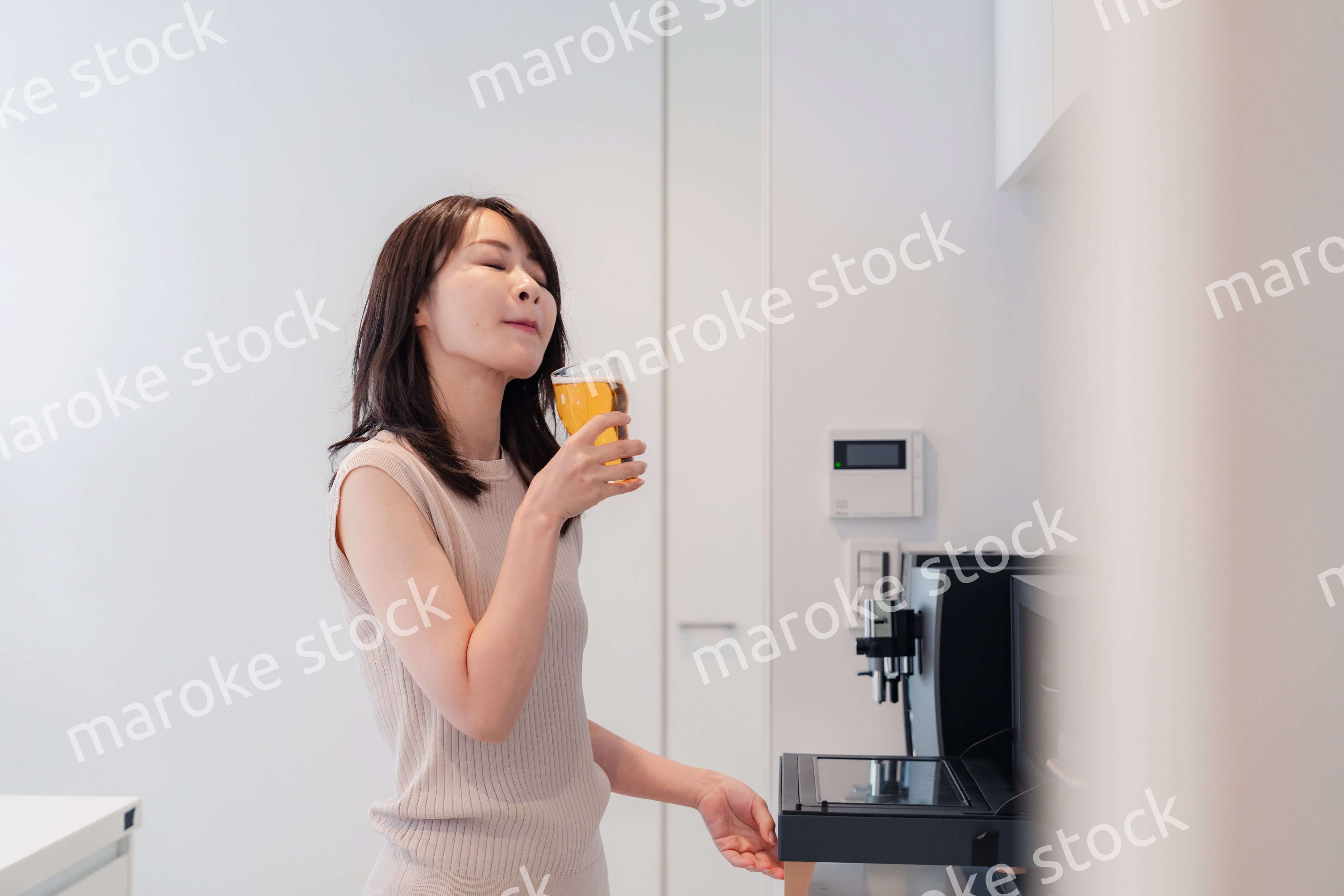 家事をしながらアルコールを飲む若い女性