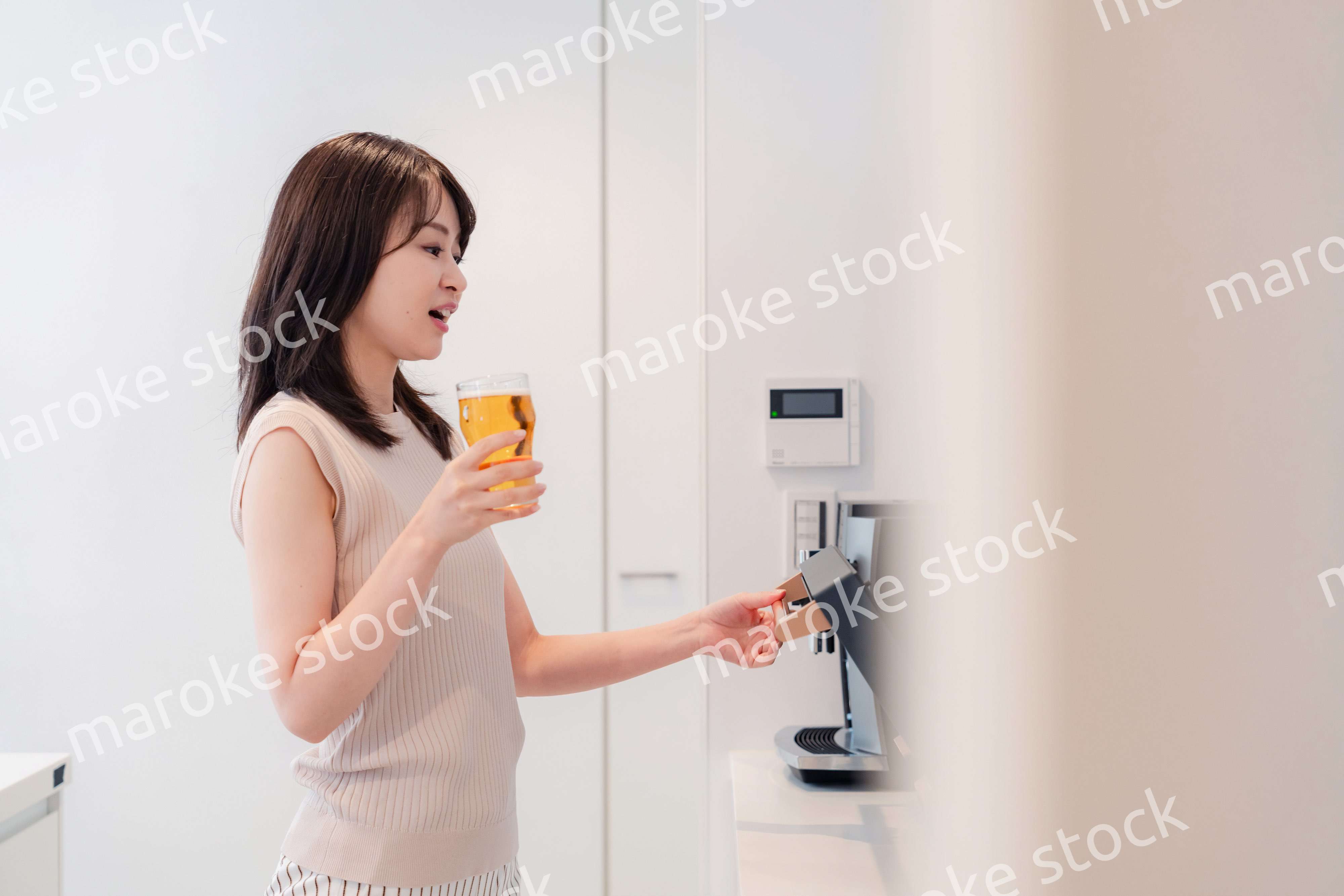 家事をしながらアルコールを飲む若い女性