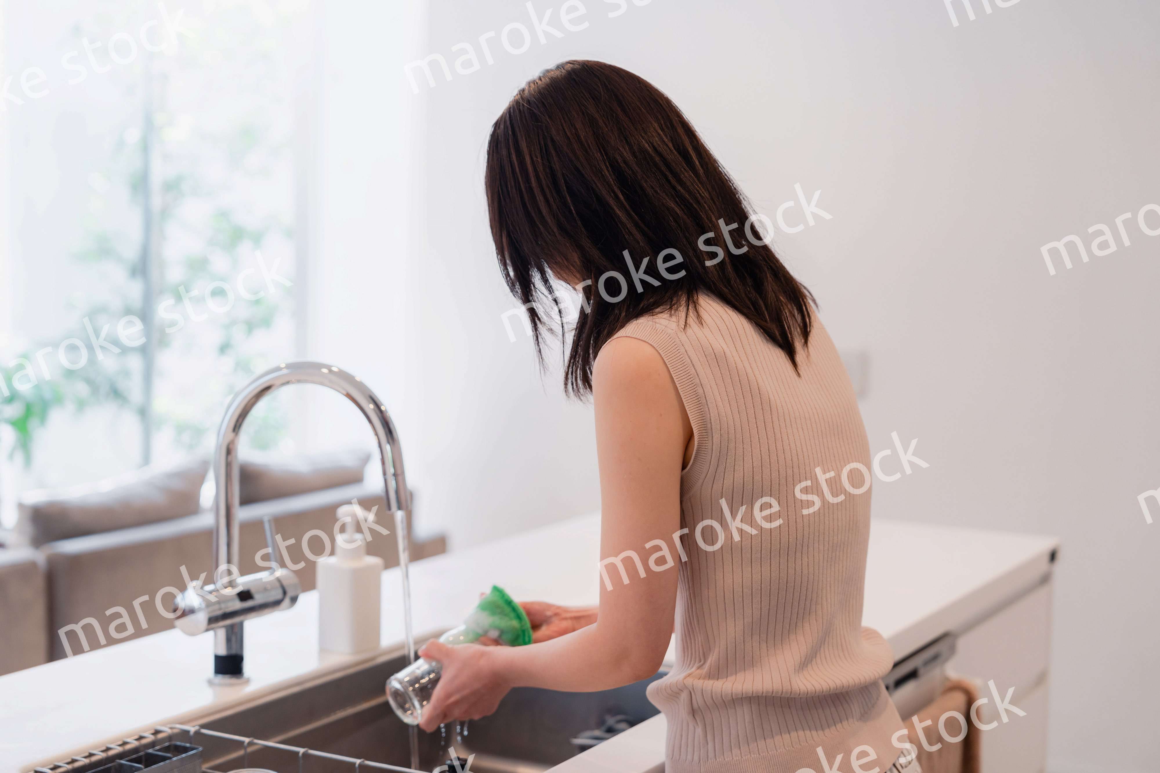 キッチンで洗い物をする若い女性