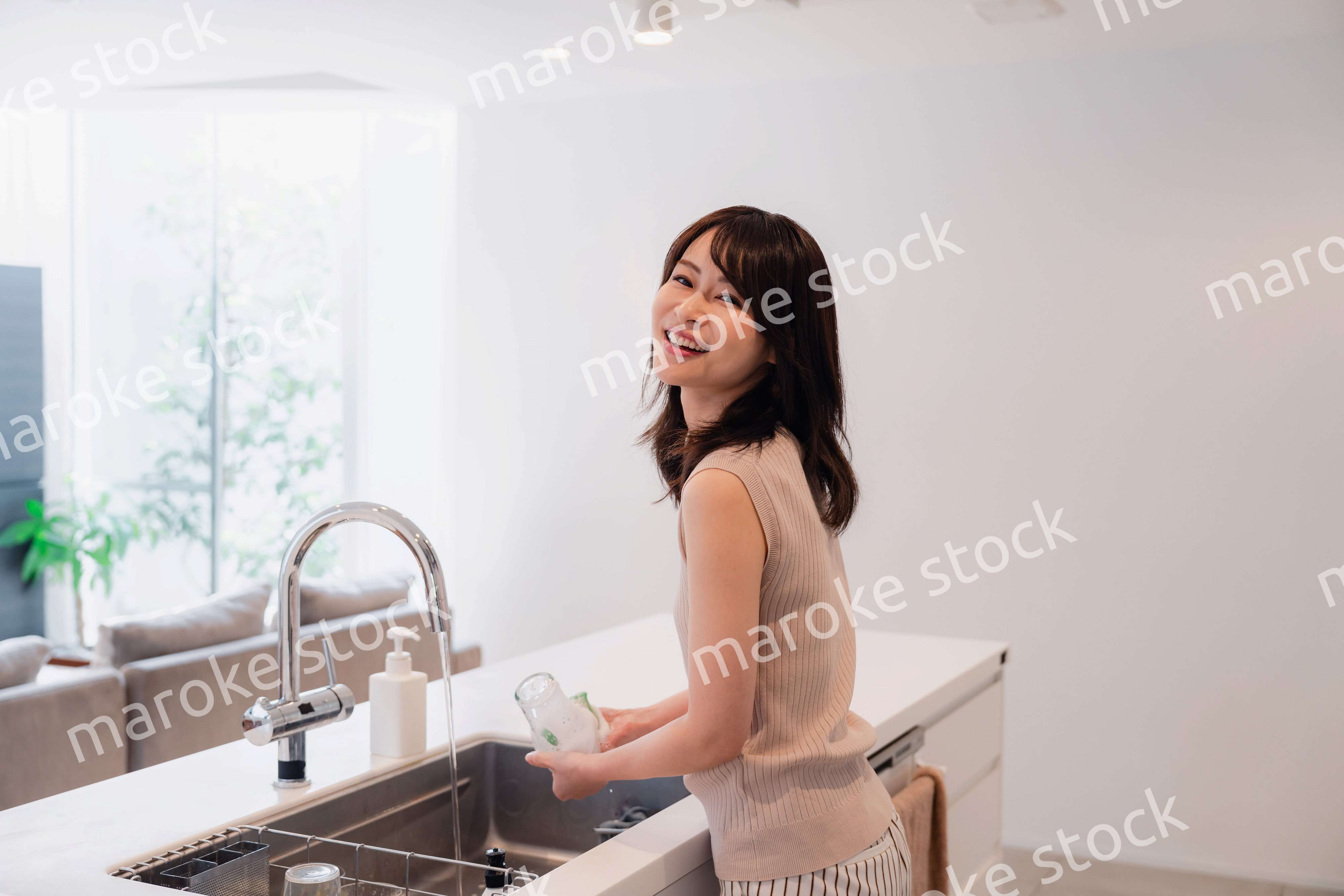 キッチンで洗い物をする若い女性