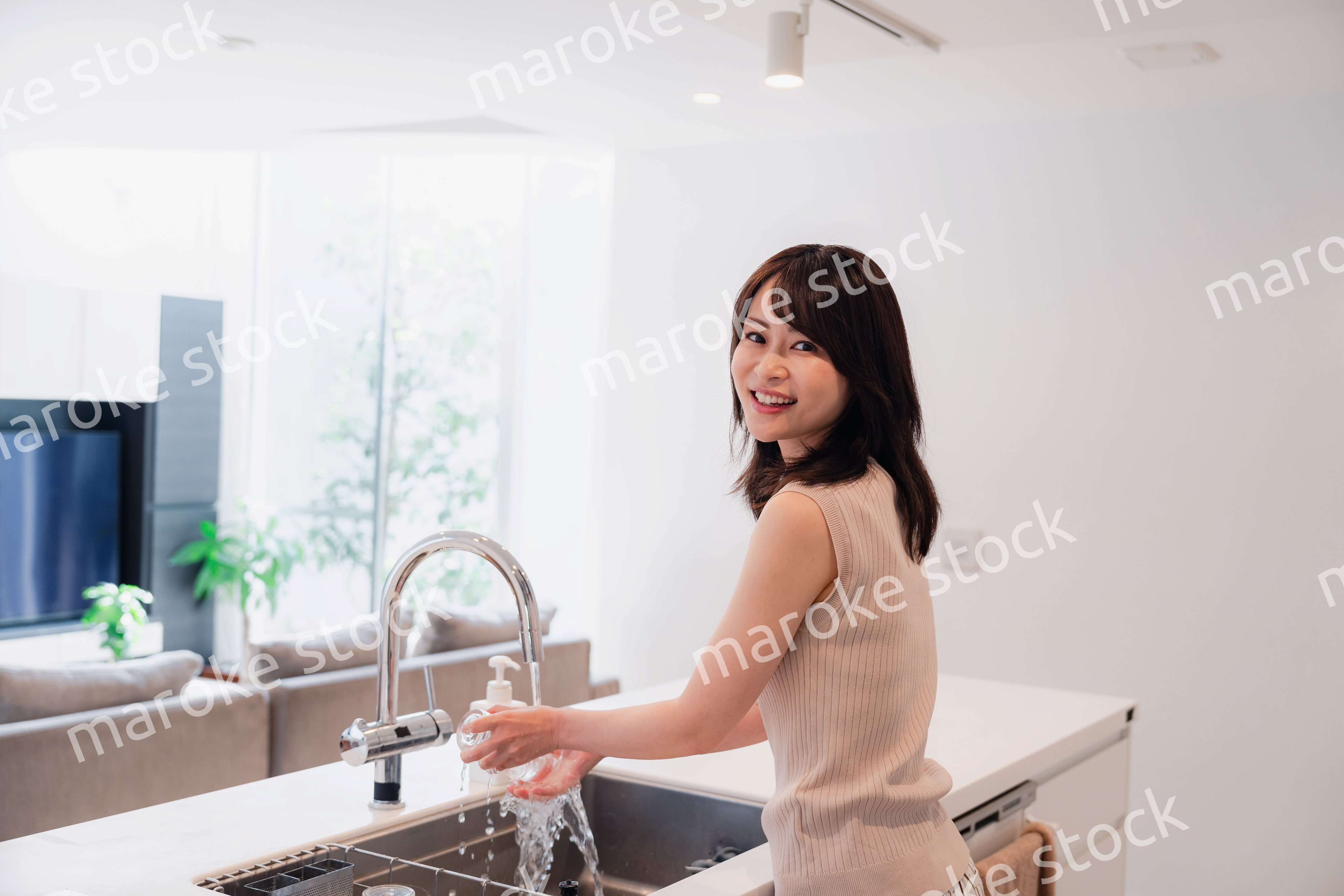 キッチンで洗い物をする若い女性