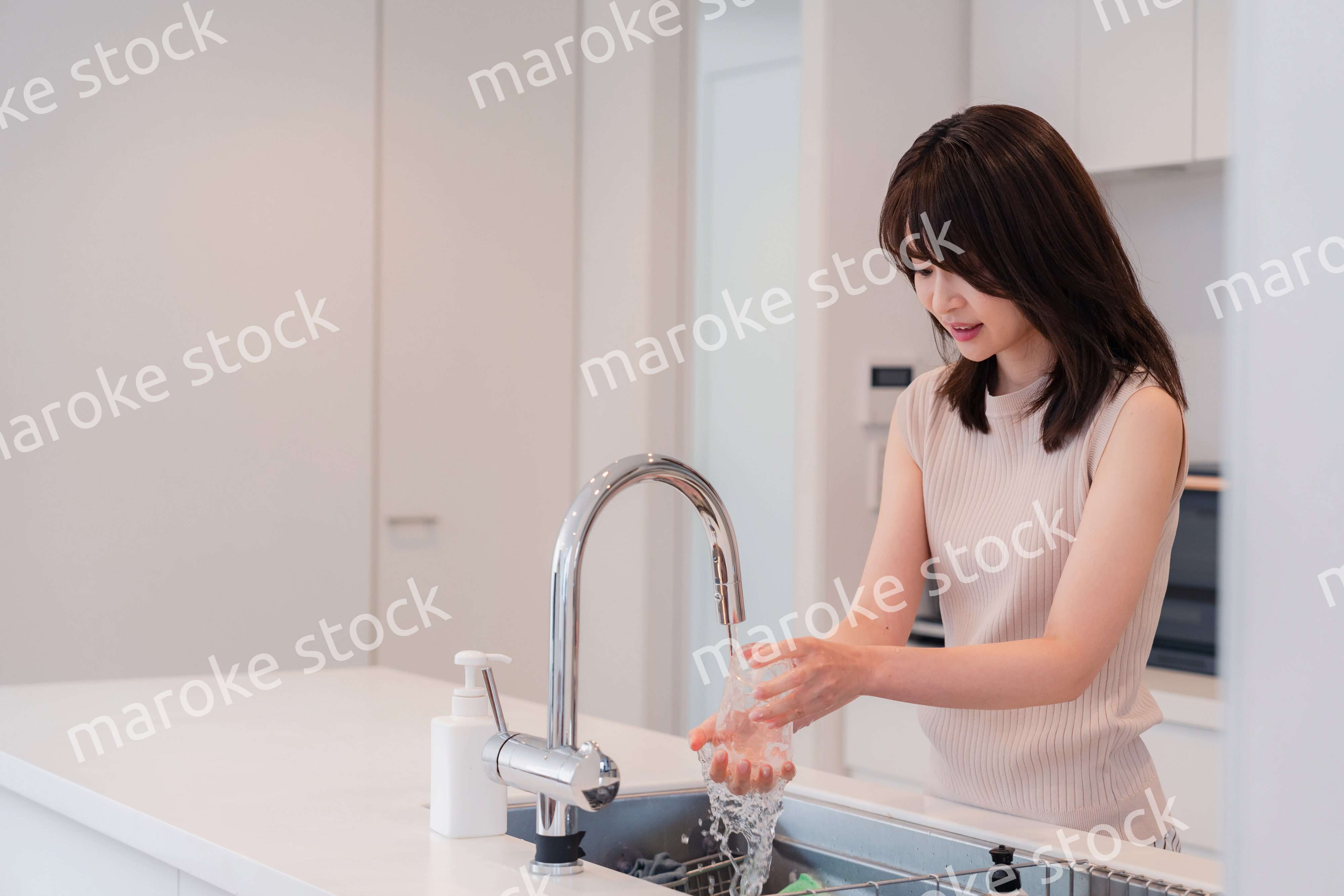 キッチンで洗い物をする若い女性