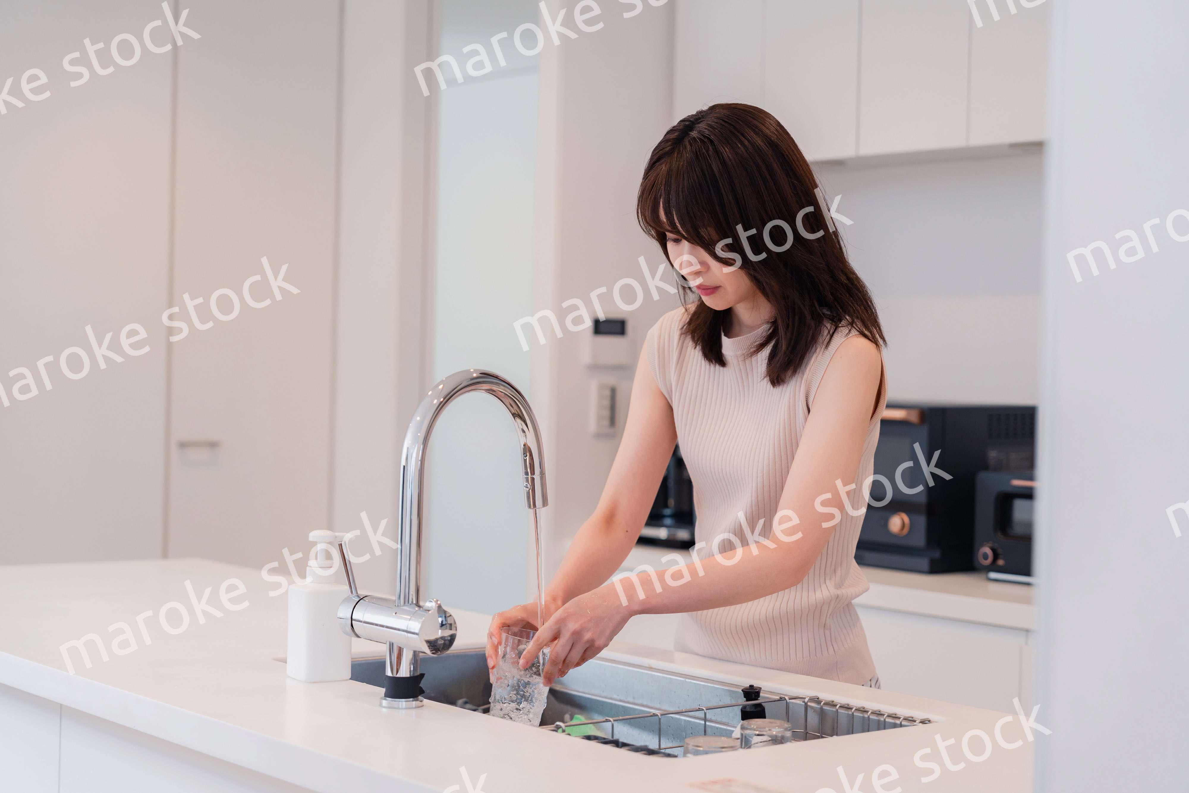 キッチンで洗い物をする若い女性