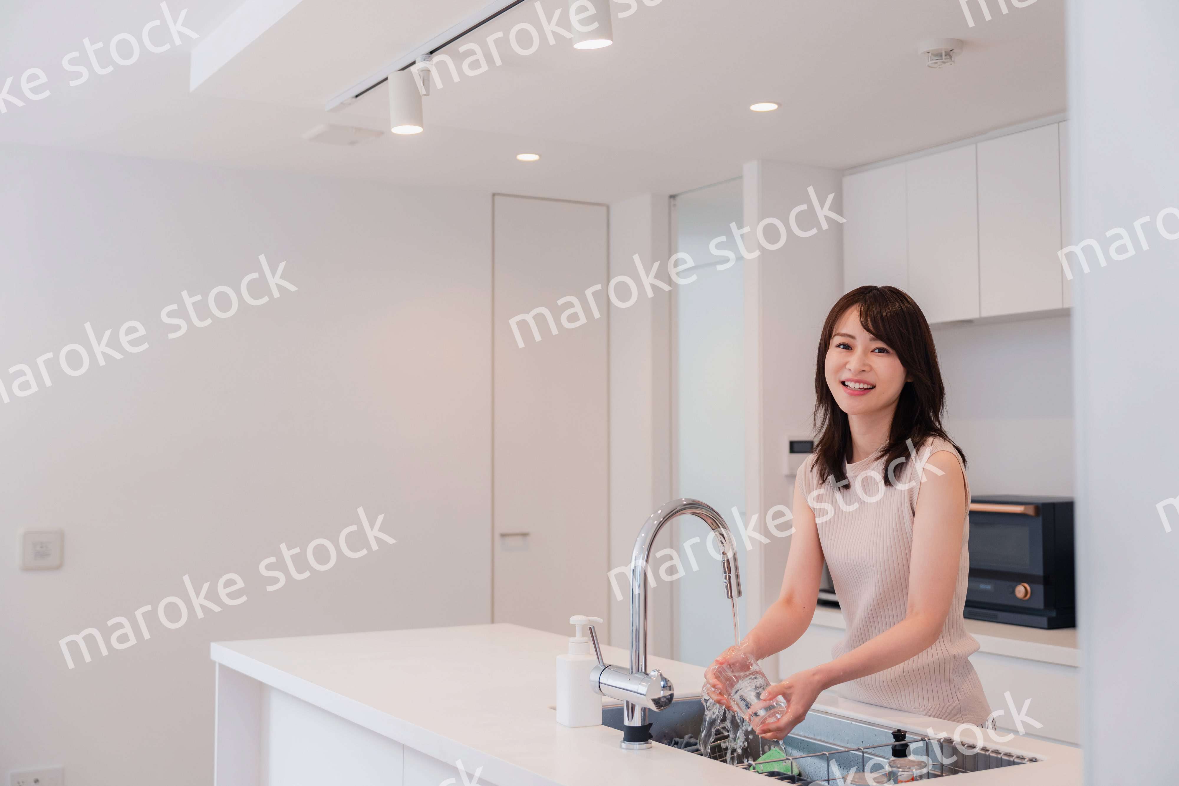 キッチンで洗い物をする若い女性