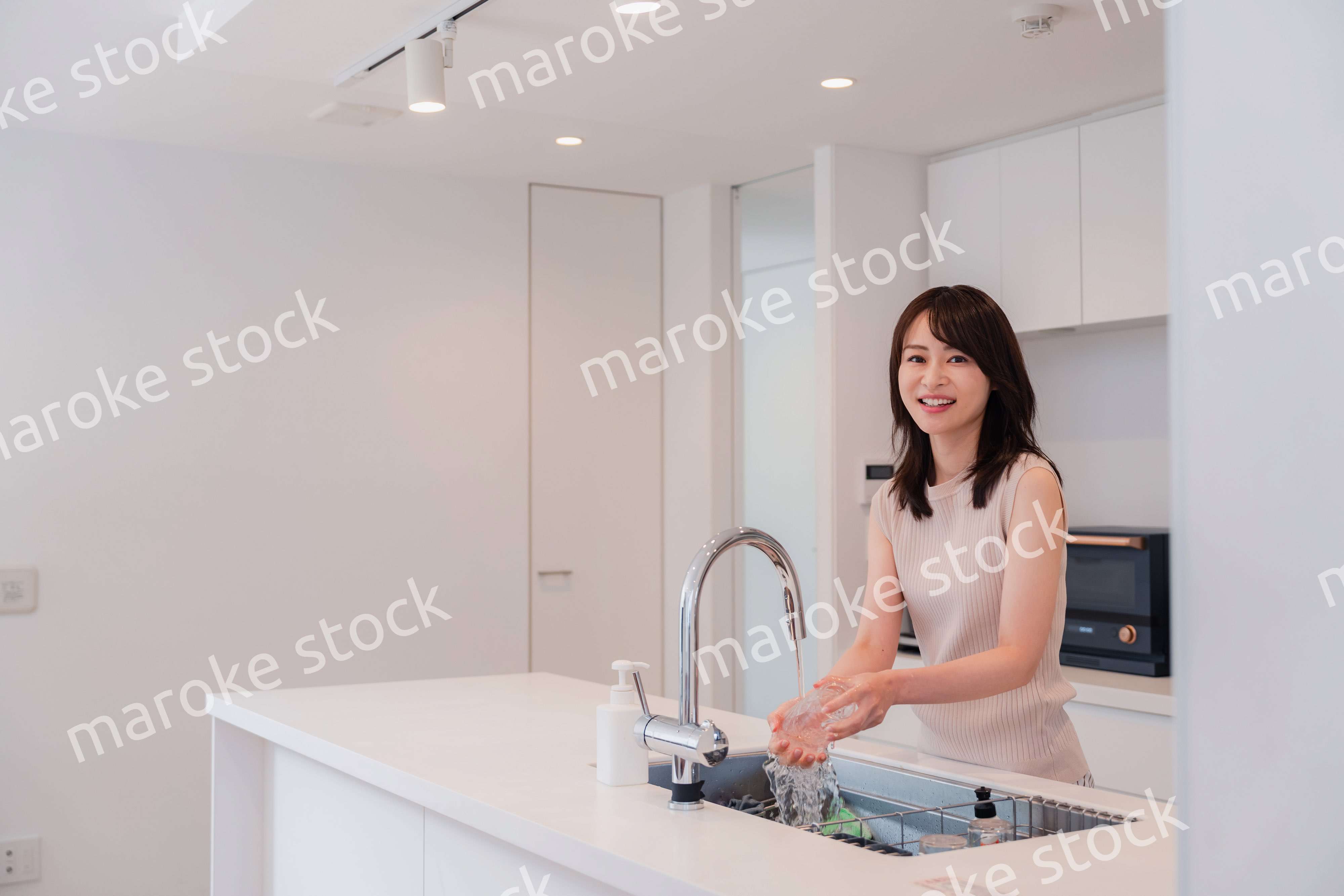 キッチンで洗い物をする若い女性