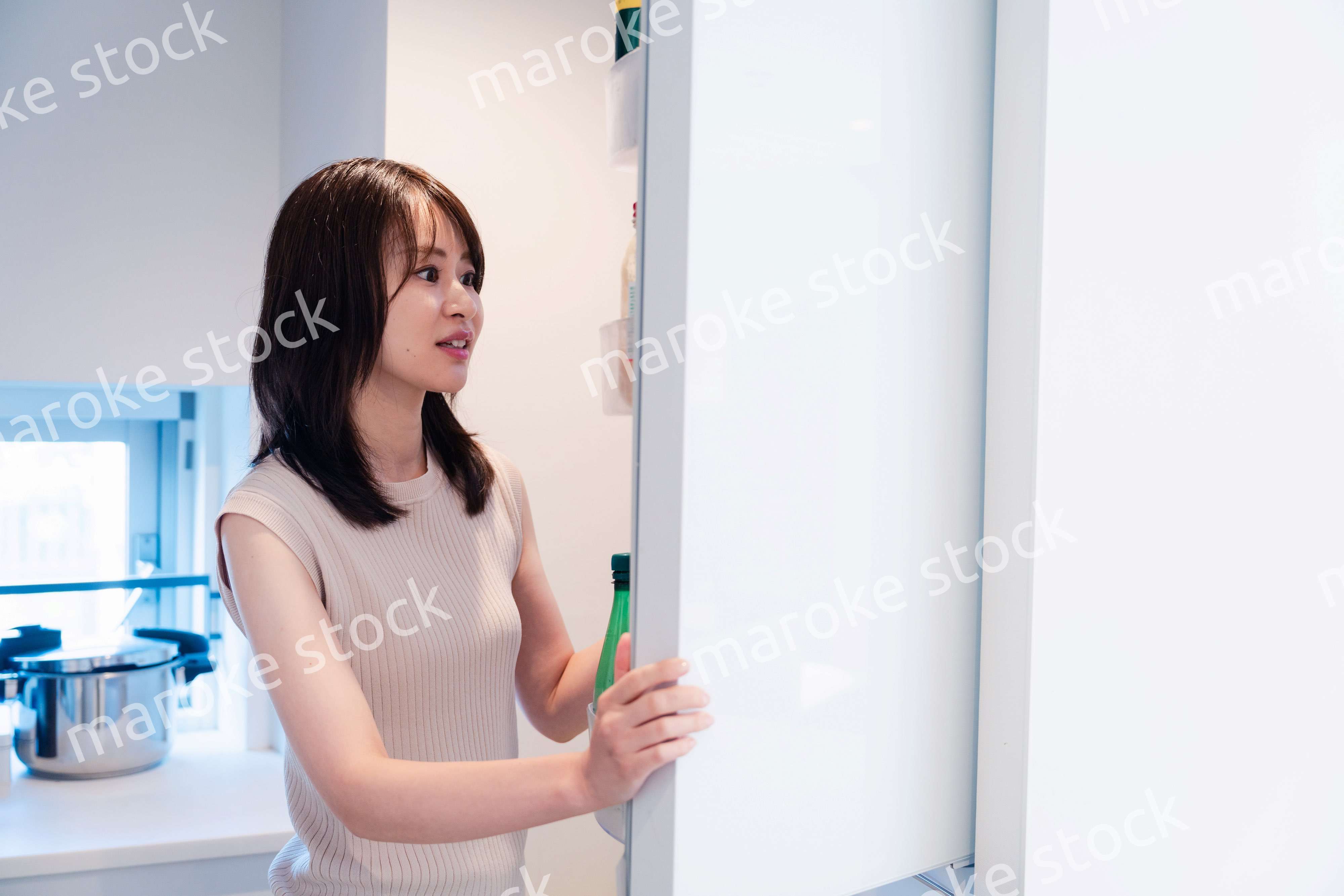 冷蔵庫を開けて物を取り出す若い女性
