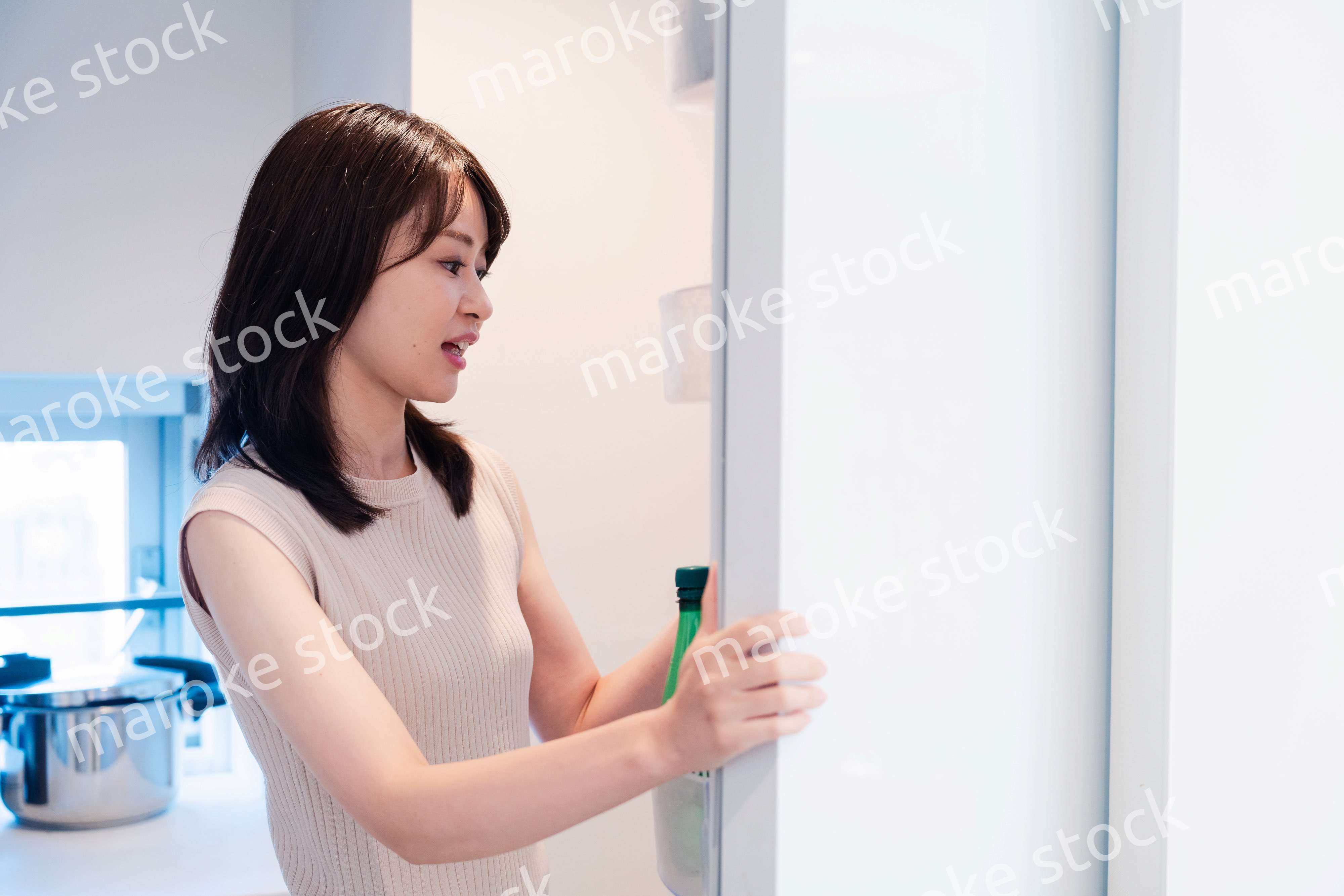 冷蔵庫を開けて物を取り出す若い女性