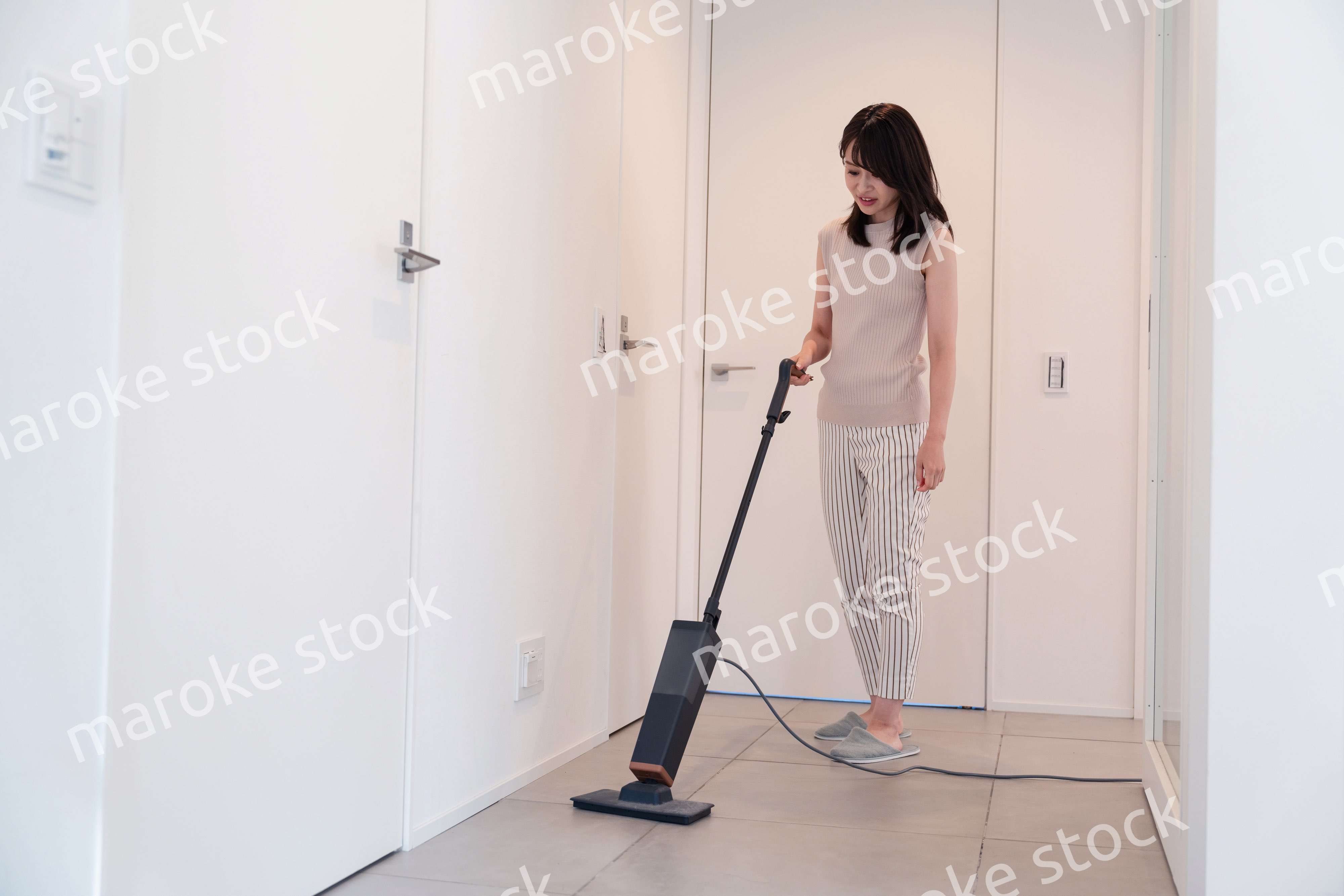 掃除機で家の掃除をする若い女性
