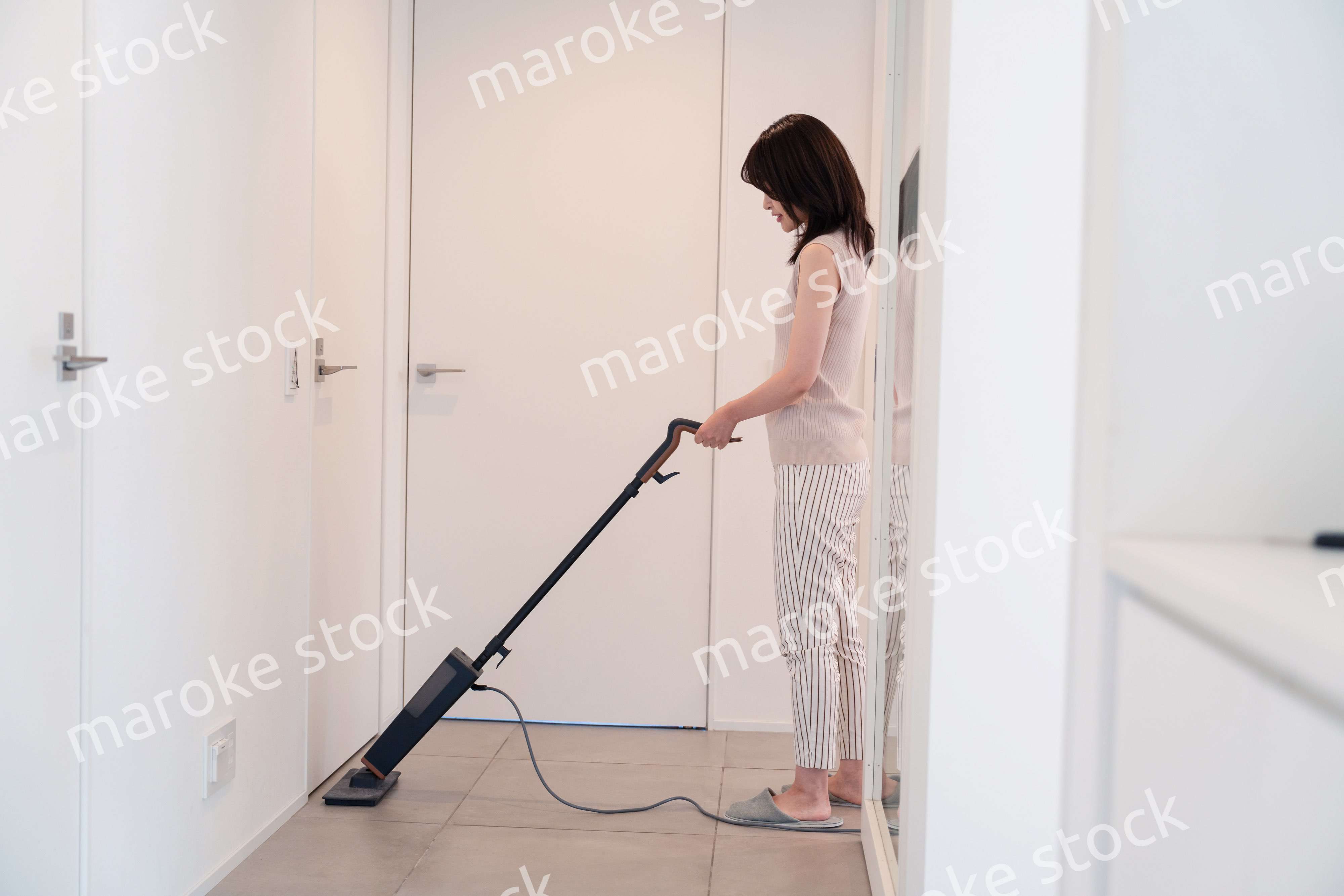掃除機で家の掃除をする若い女性