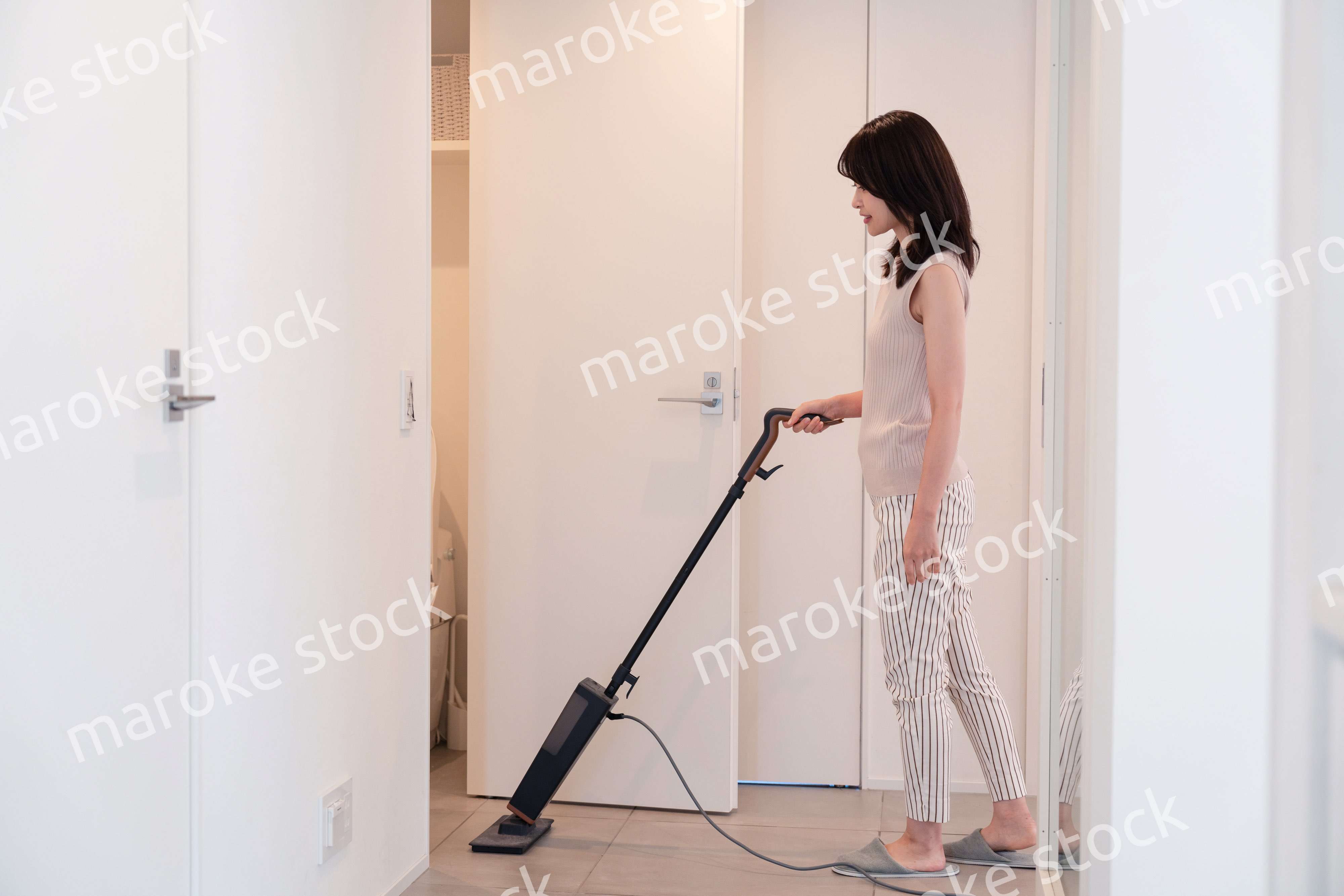 掃除機で家の掃除をする若い女性