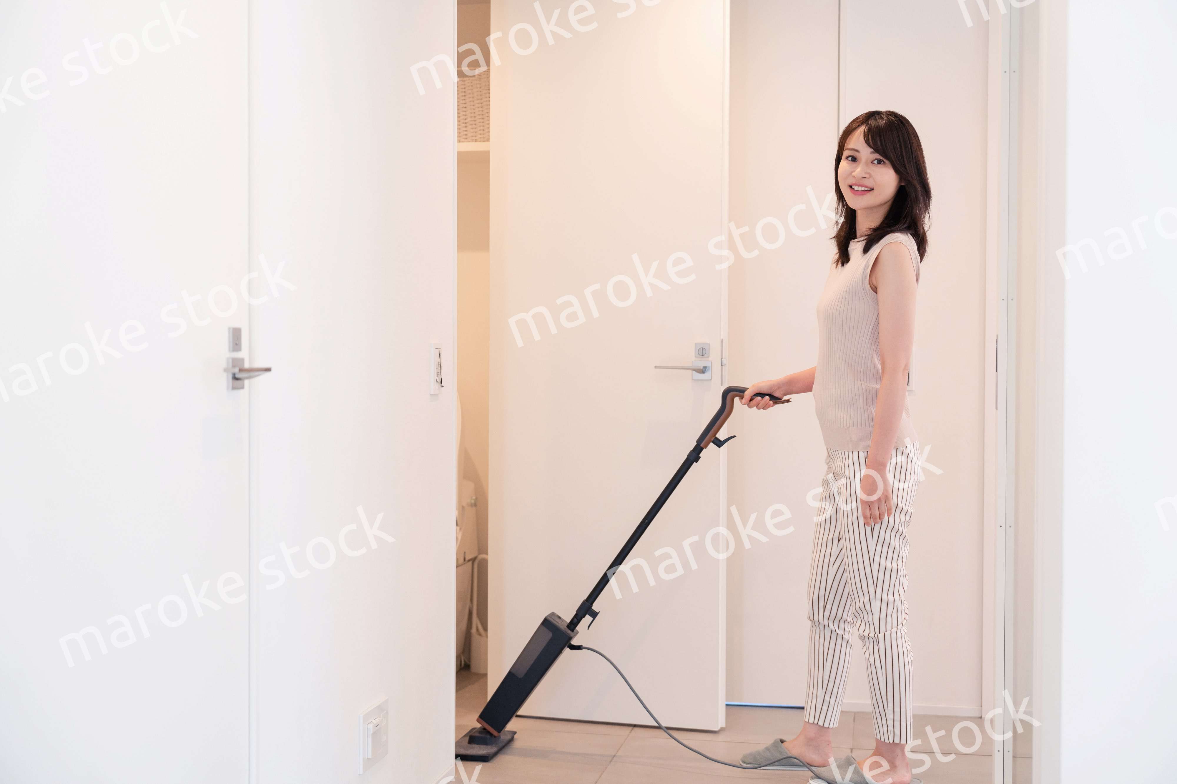 掃除機で家の掃除をする若い女性