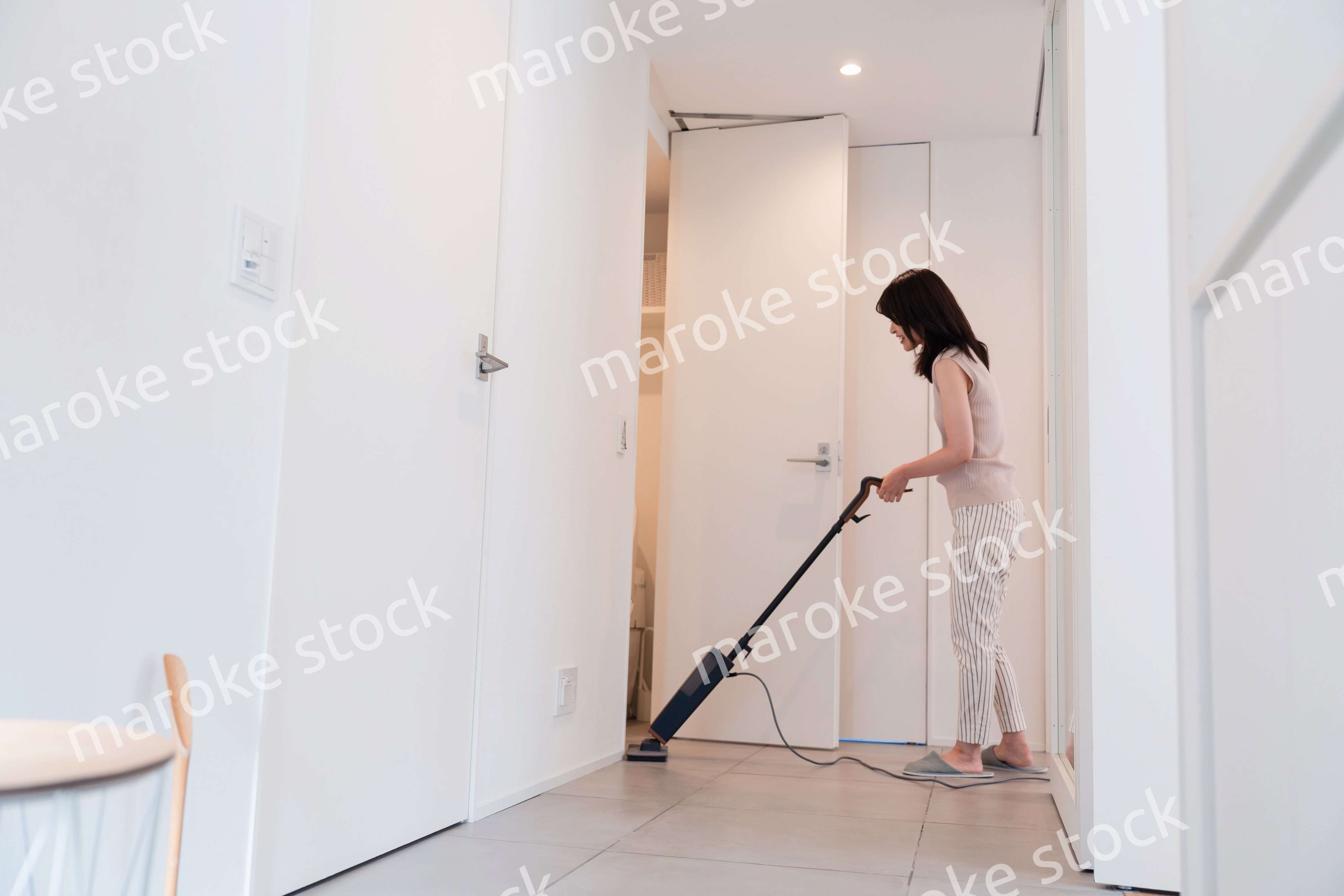 掃除機で家の掃除をする若い女性