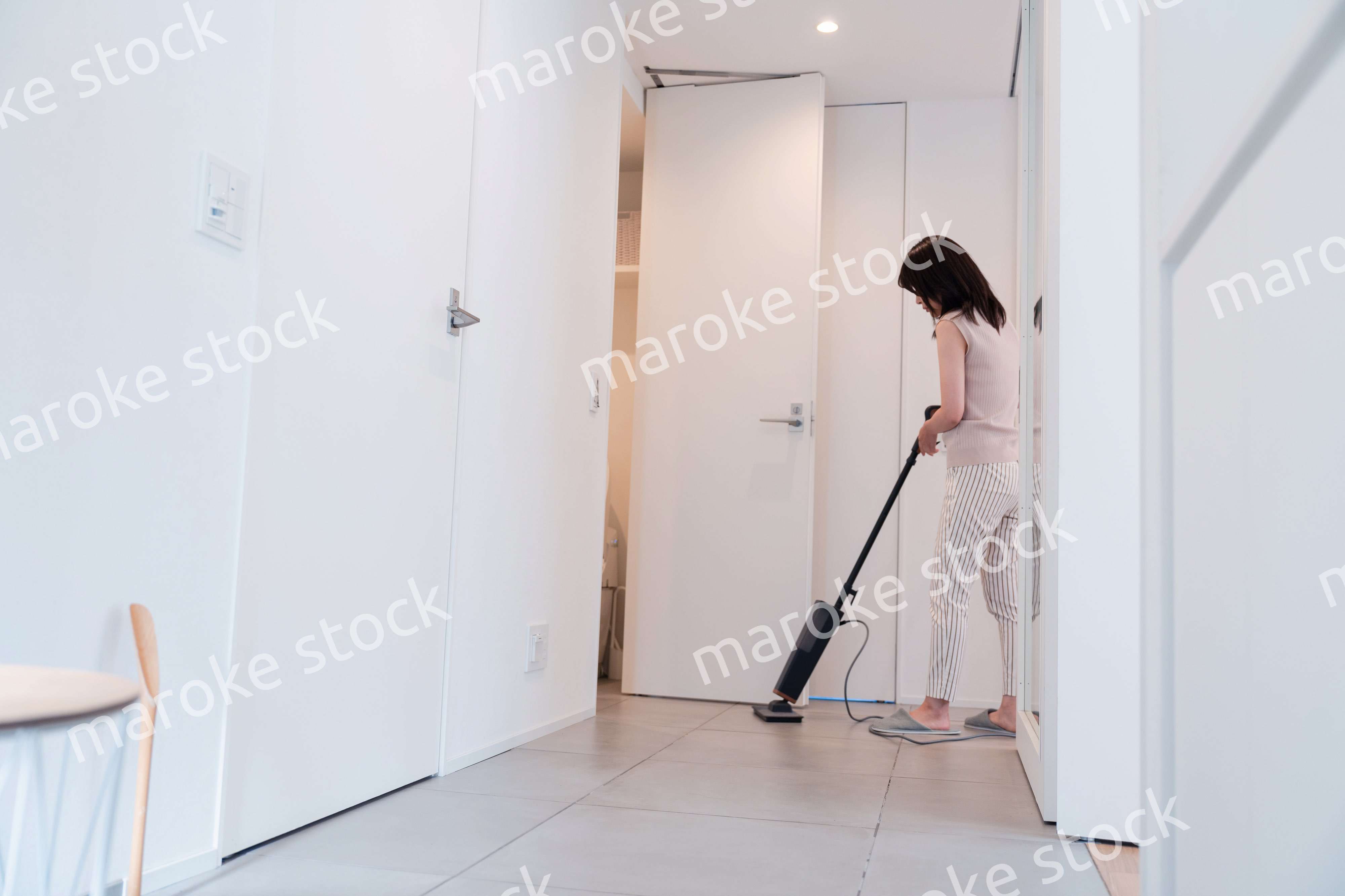 掃除機で家の掃除をする若い女性