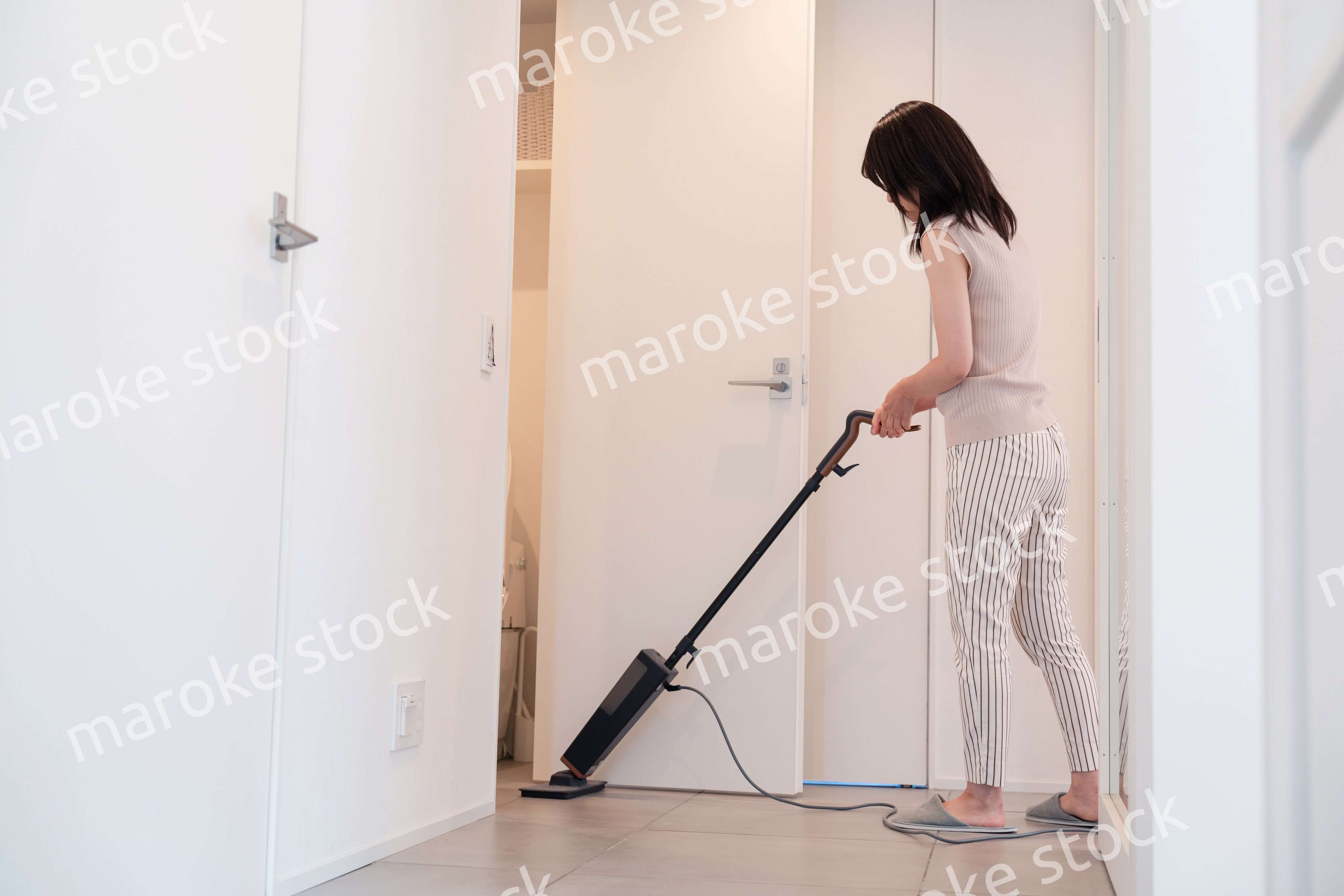 掃除機で家の掃除をする若い女性