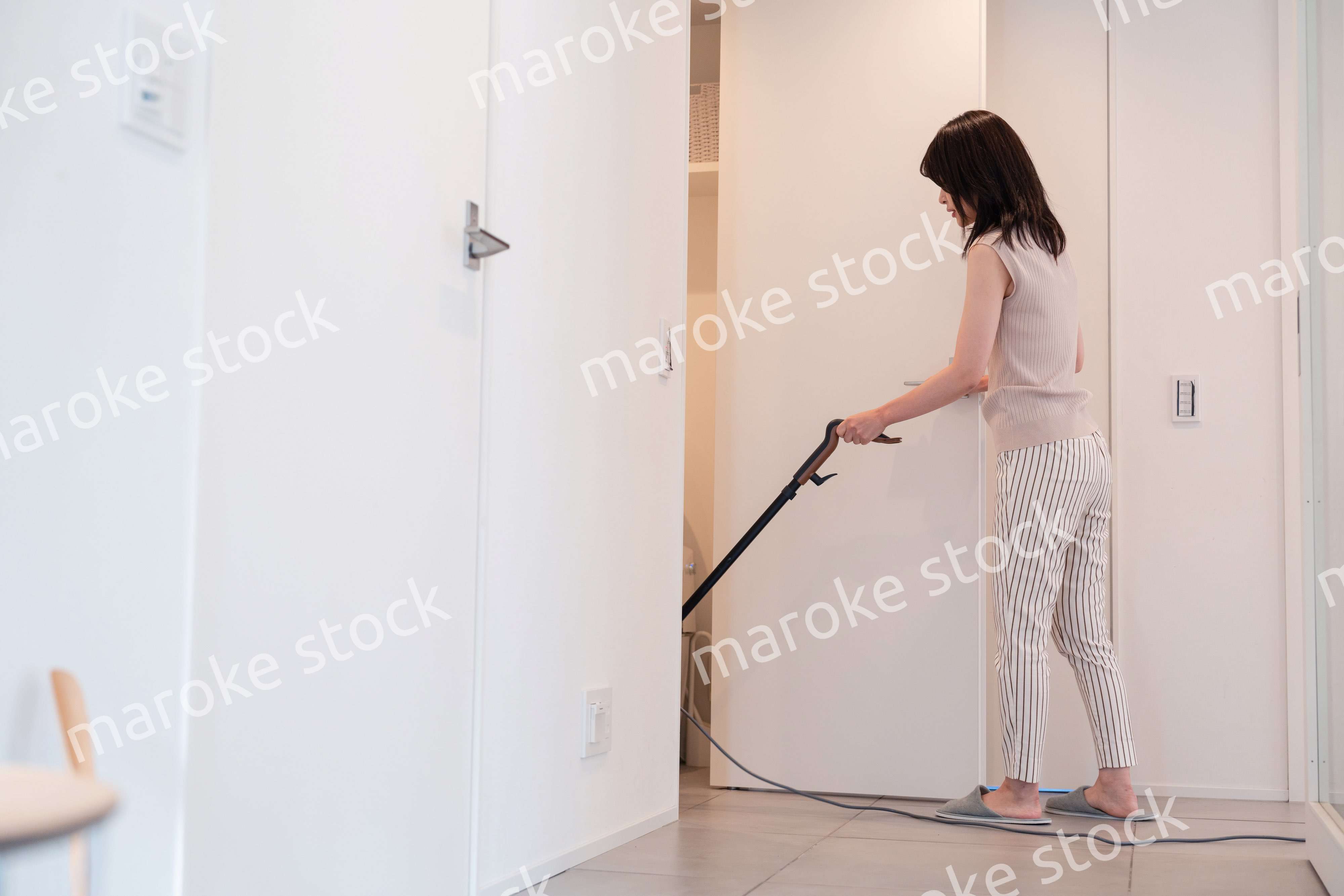 掃除機で家の掃除をする若い女性