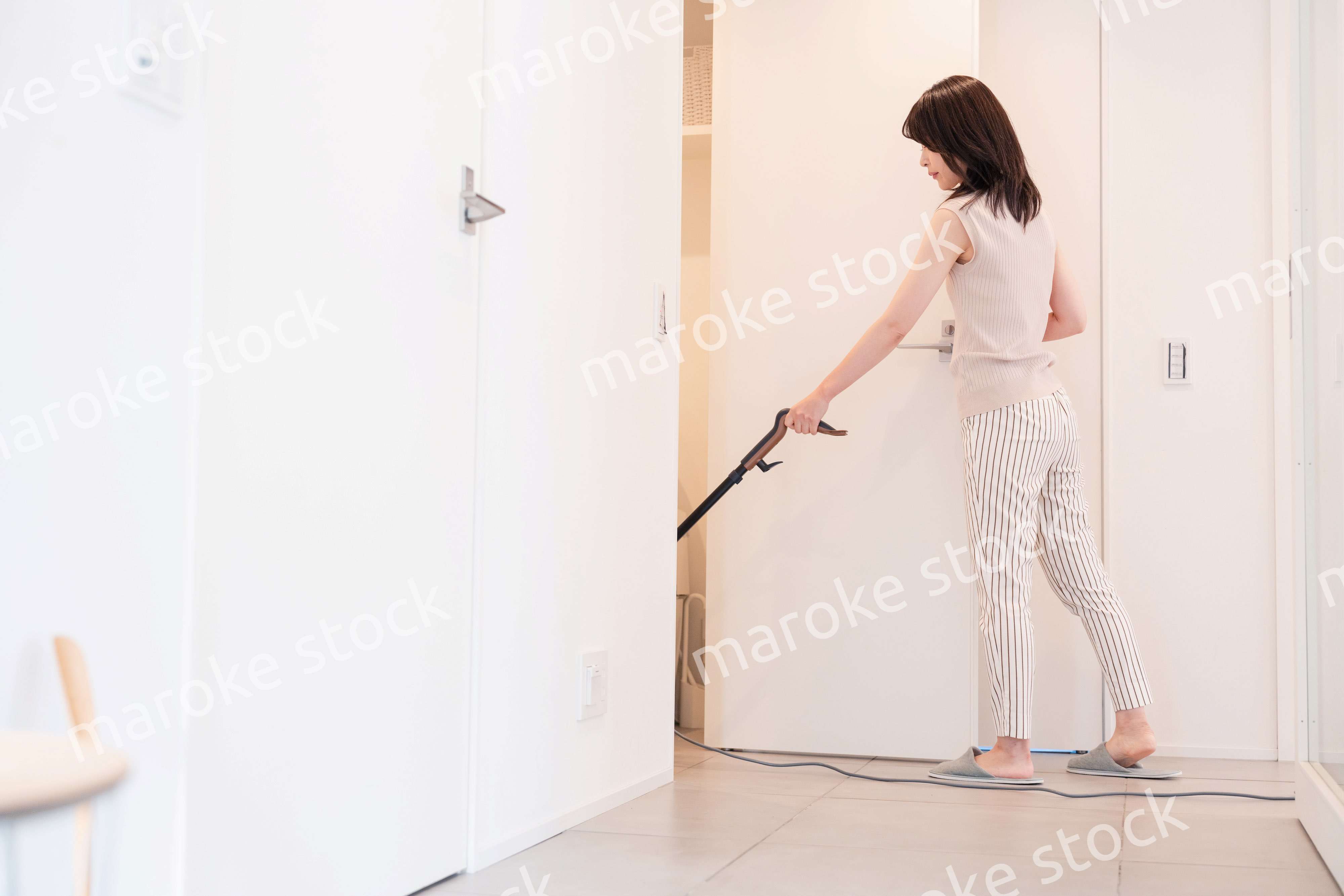 掃除機で家の掃除をする若い女性