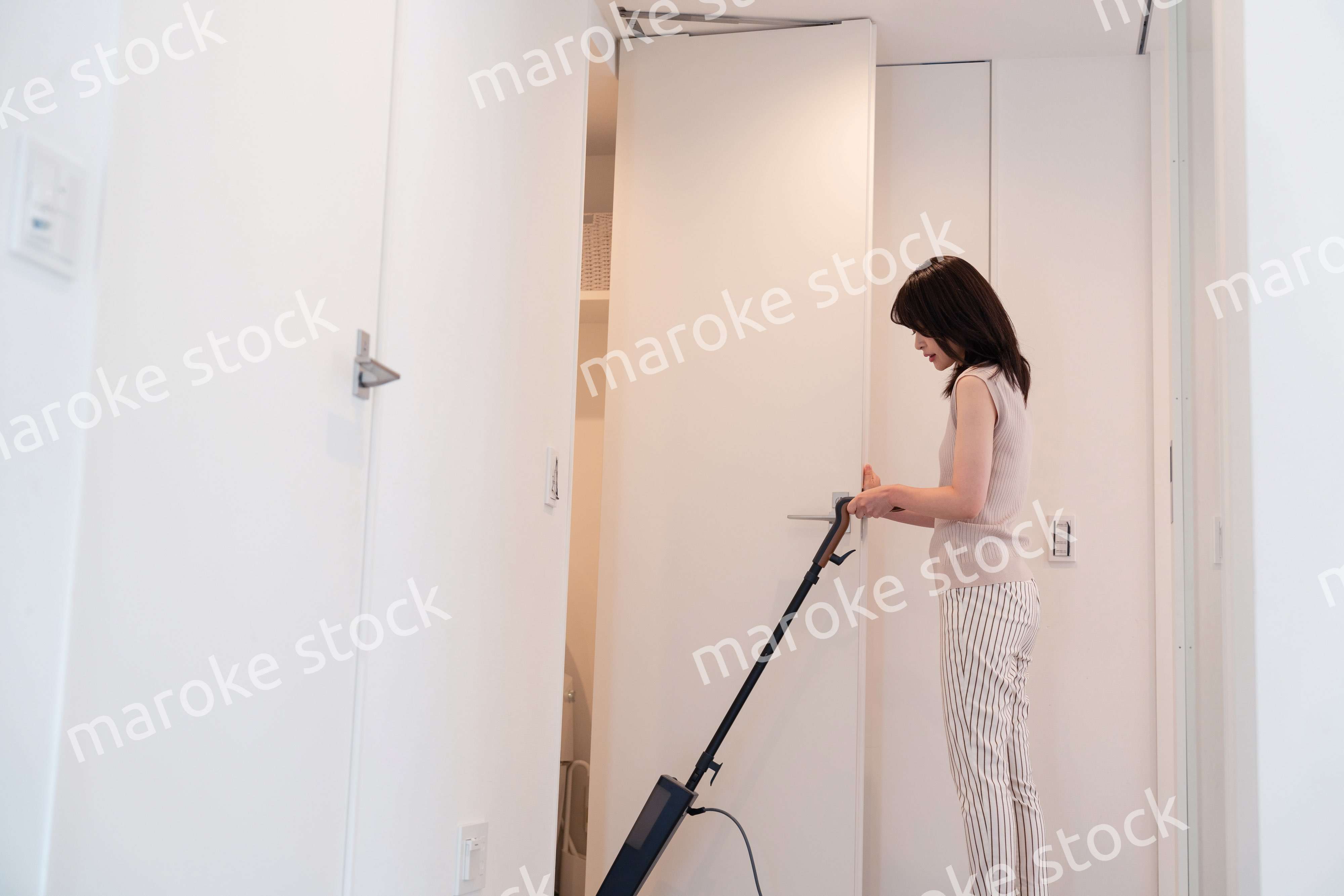 掃除機で家の掃除をする若い女性