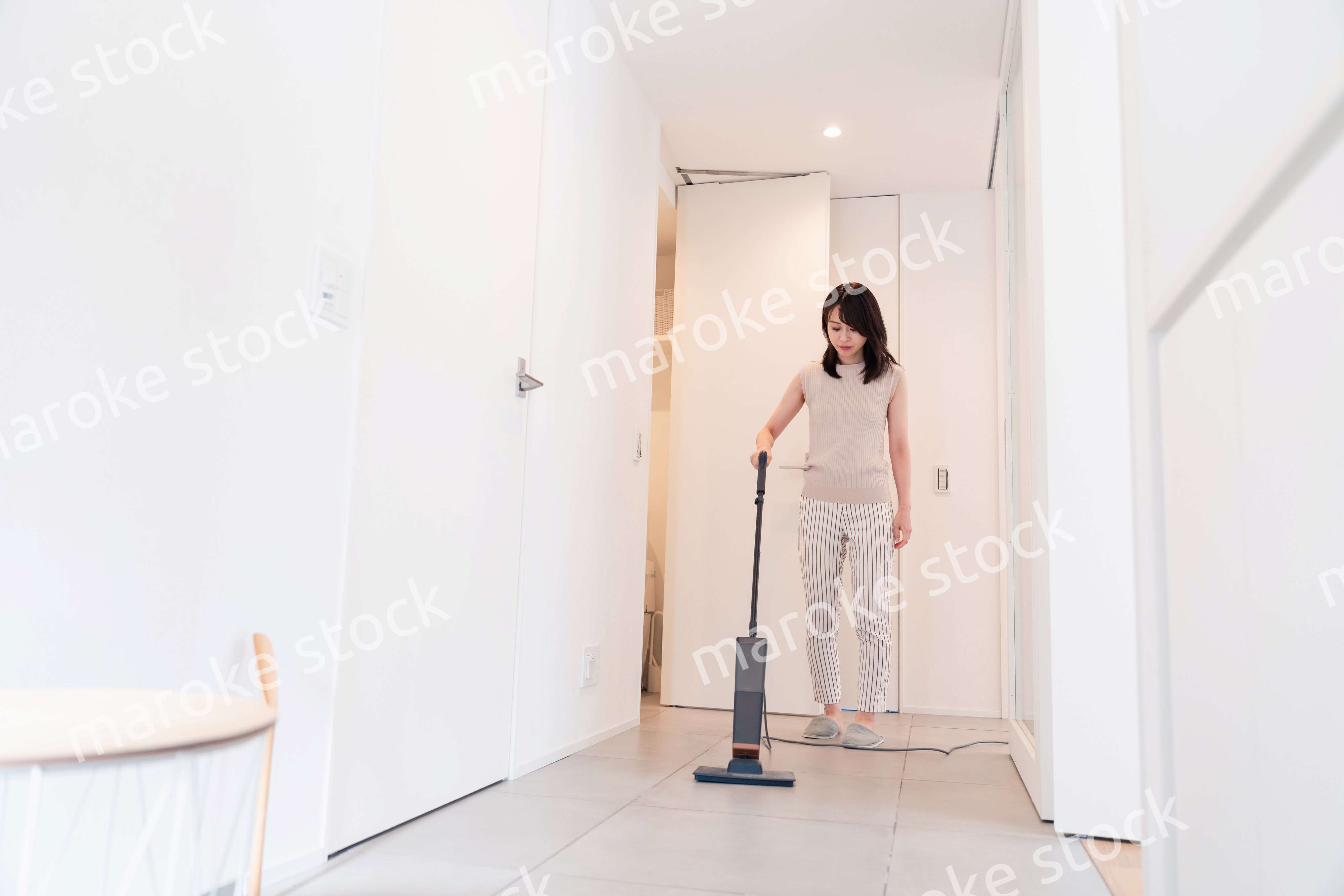 掃除機で家の掃除をする若い女性