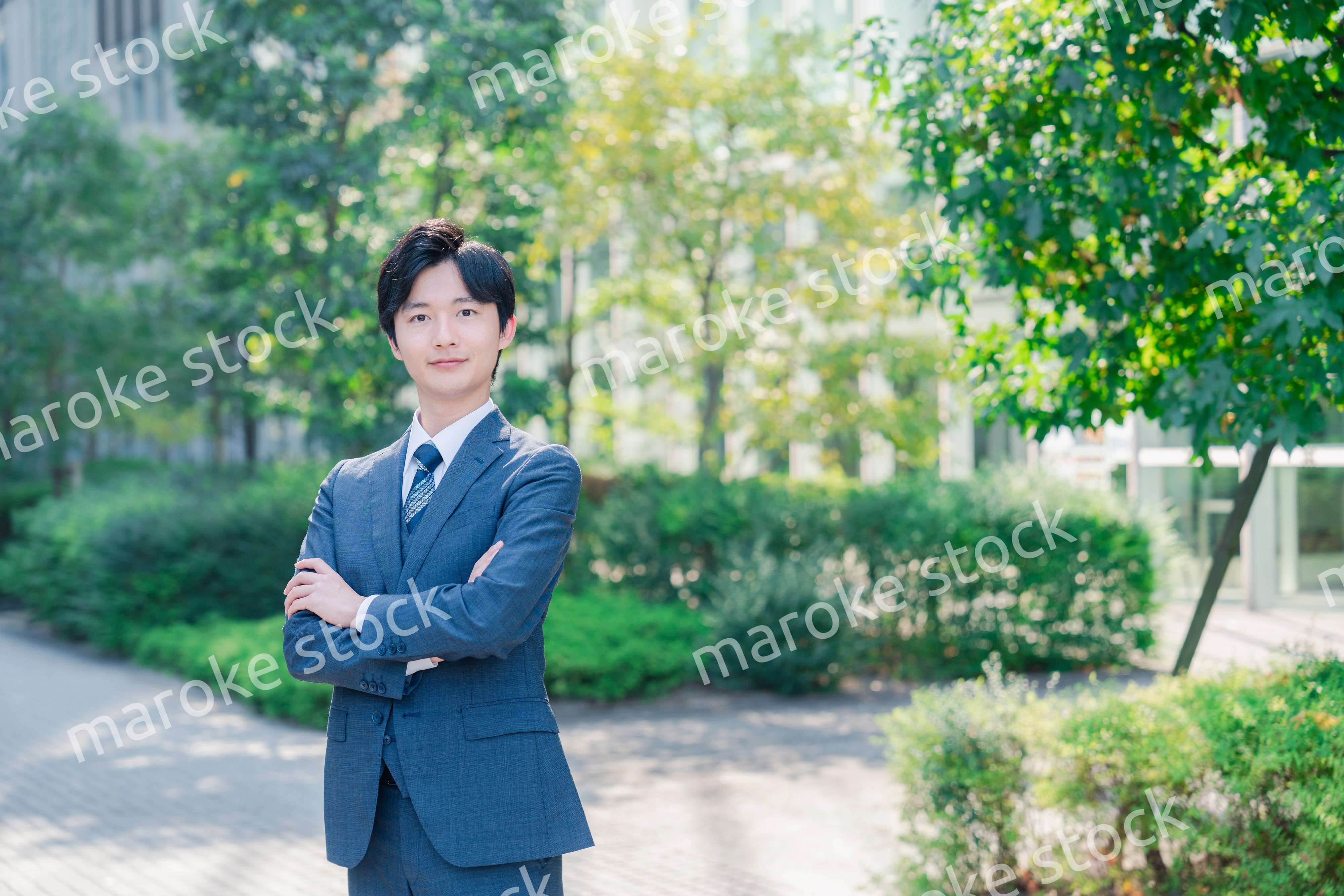 スーツを着て腕を組む若いビジネスマン