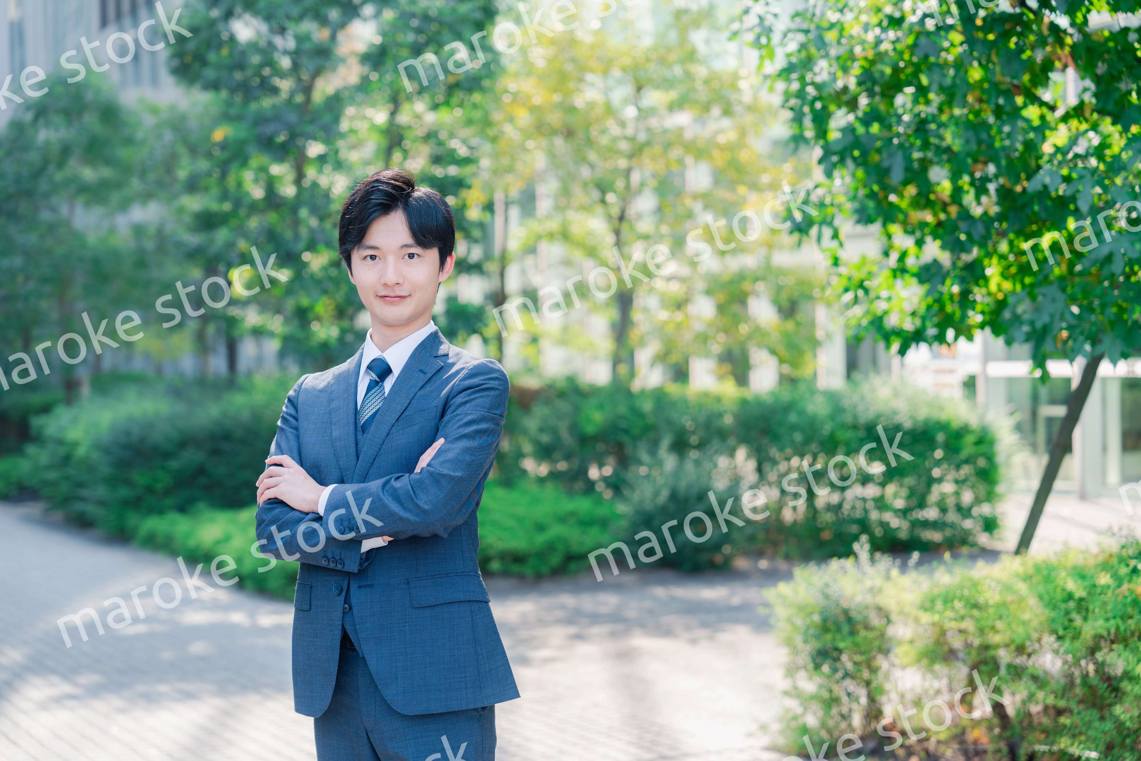 スーツを着て腕を組む若いビジネスマン