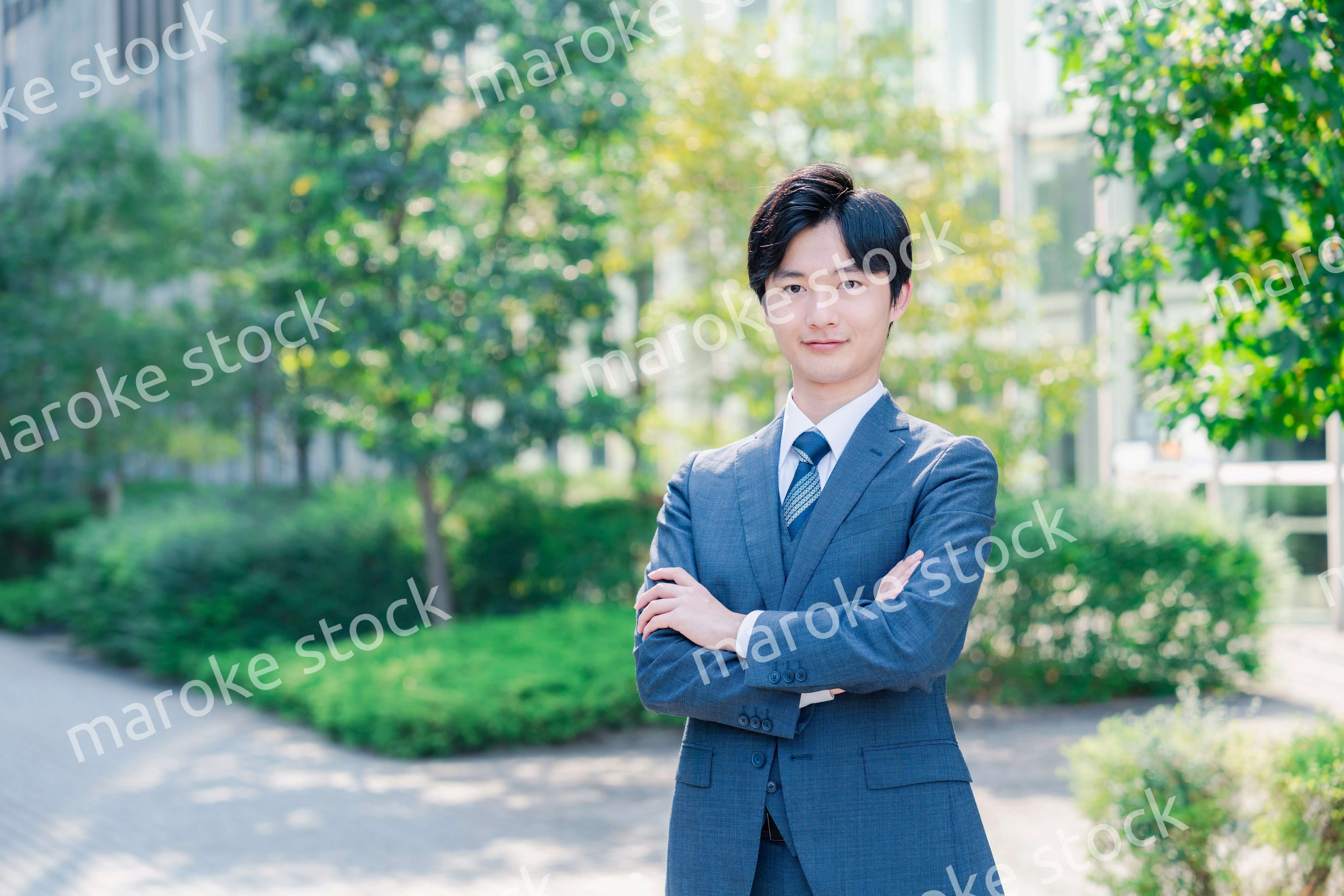 スーツを着て腕を組む若いビジネスマン