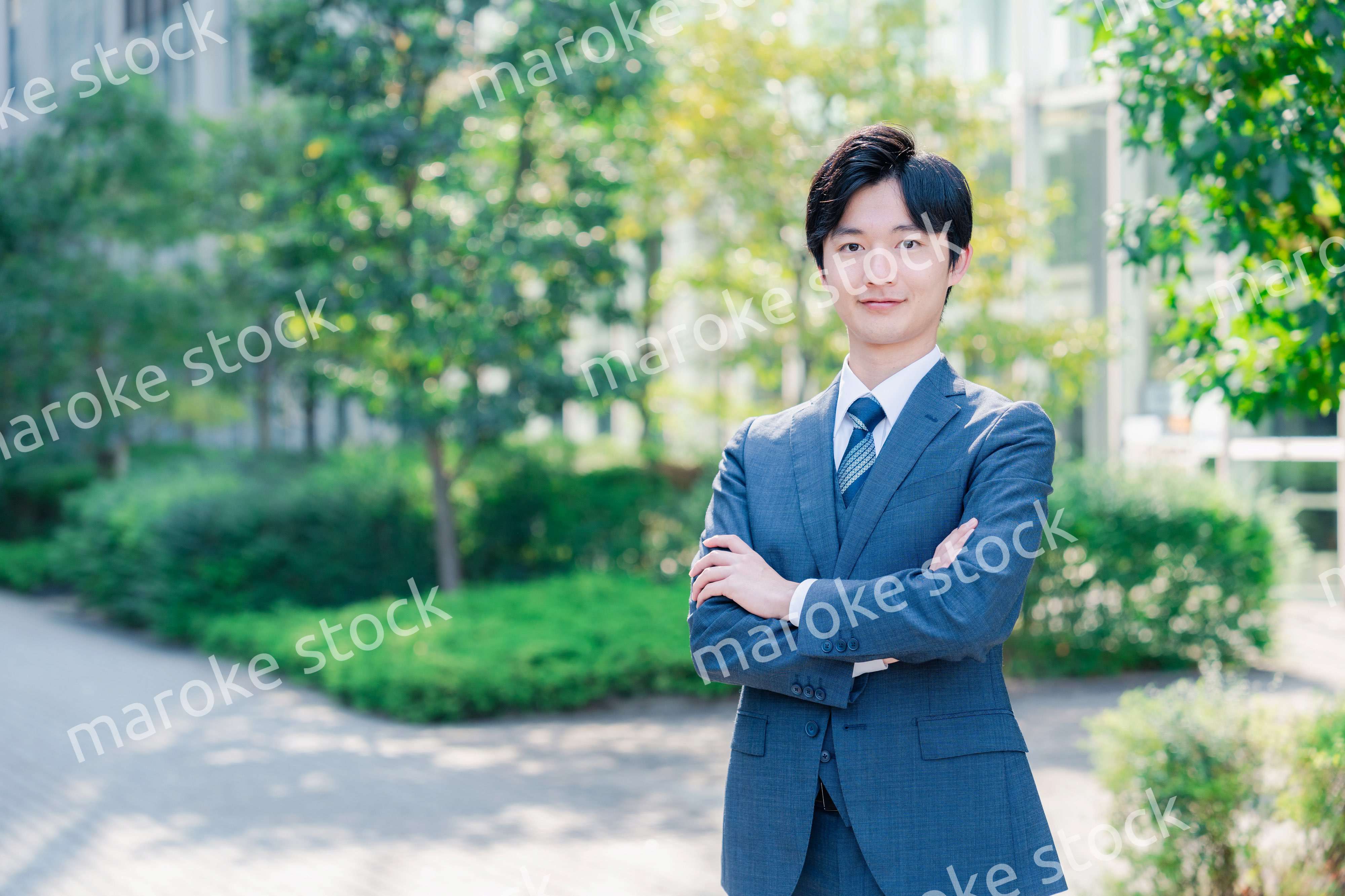 スーツを着て腕を組む若いビジネスマン