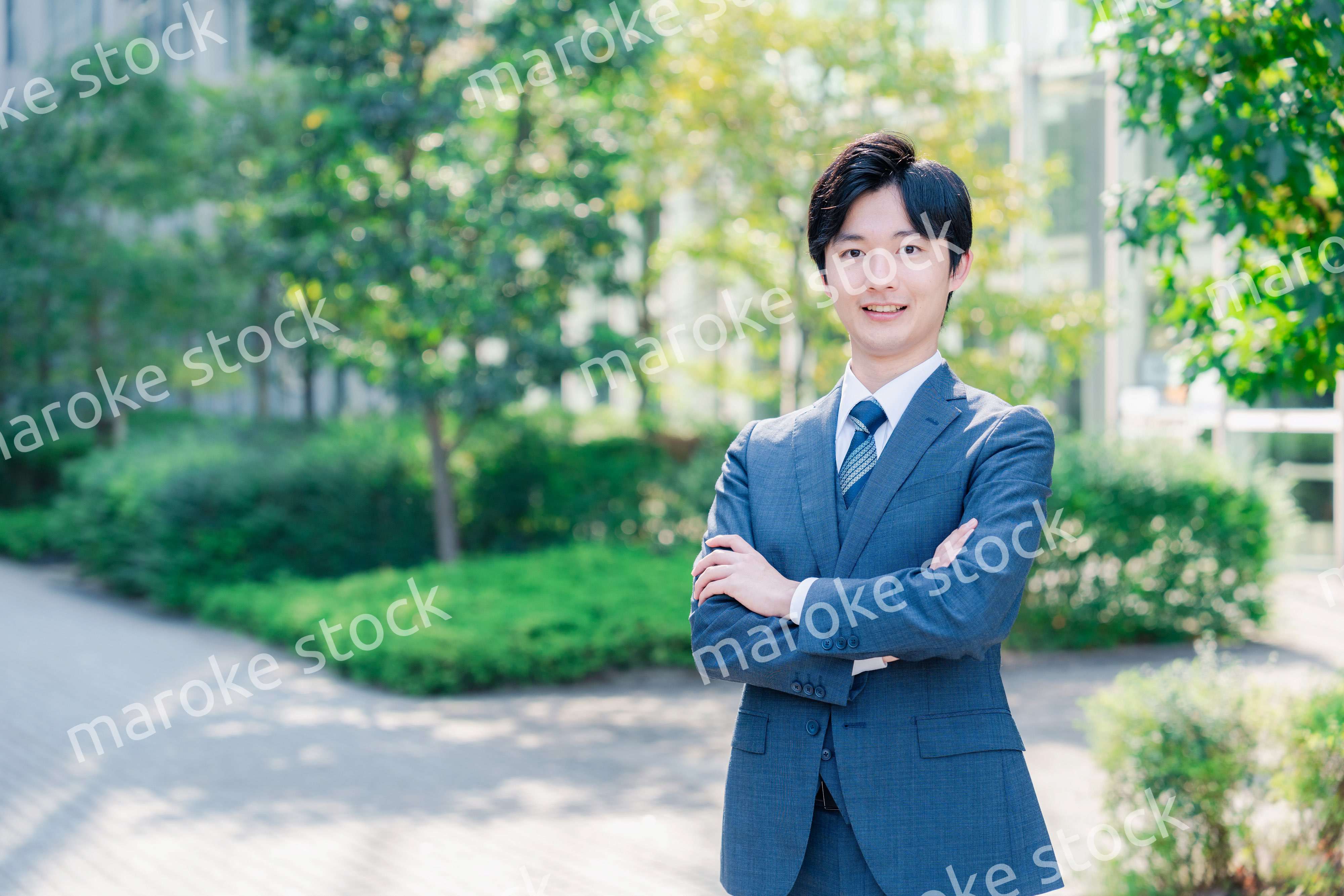 スーツを着て腕を組む若いビジネスマン